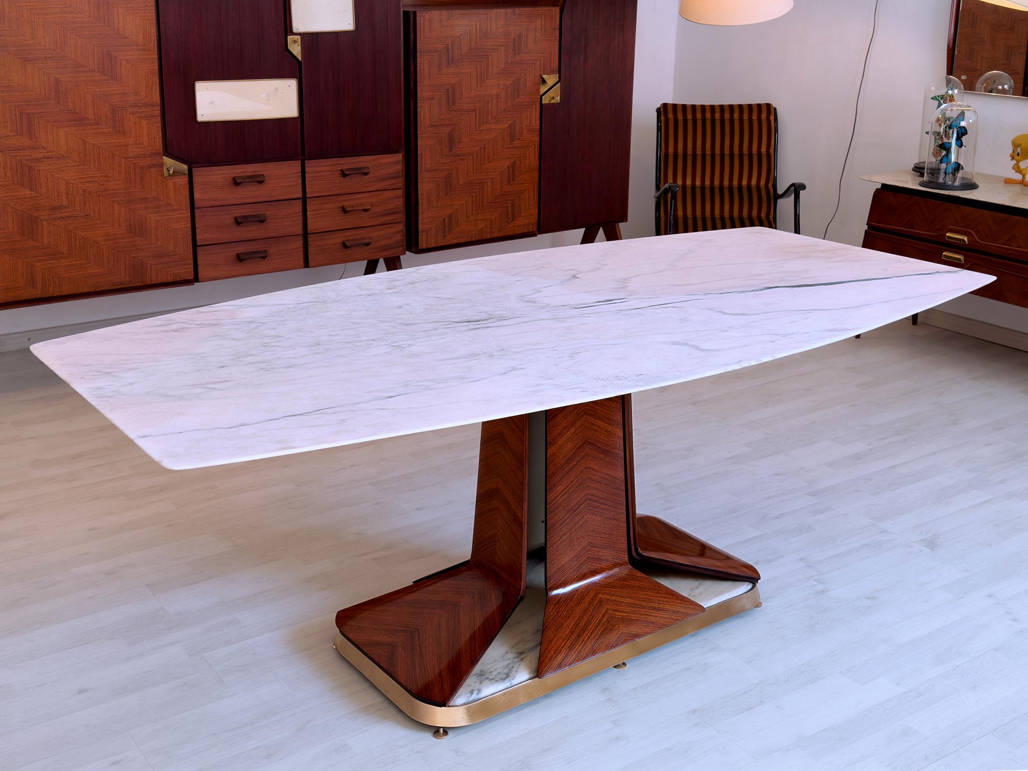Cette superbe table de salle à manger des années 1950 est attribuable au design de Vittorio Dassi et/ou à la production de La Permanente Mobili Cantù.
Il se caractérise par un plan supérieur en marbre blanc de Carrare à la forme sculpturale unique,