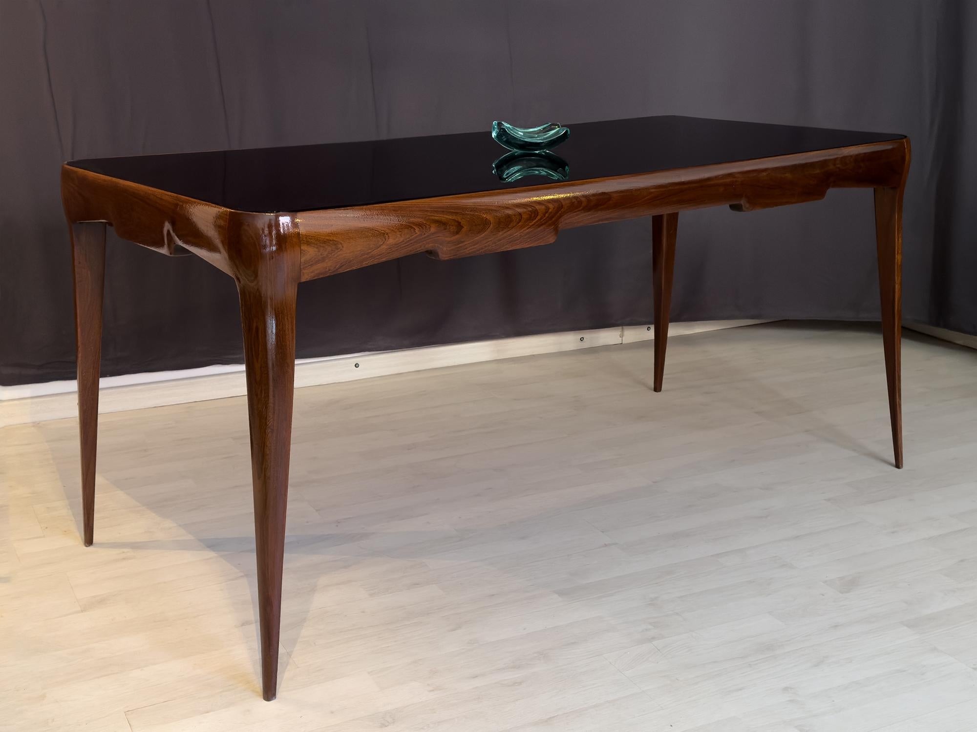 Stunning Italian walnut dining table of the 1950s, characterized by a unique soft design, very stylish and charming.
Its seductive structure, very thin and slight, is unexpectedly very solid, balanced and stable.
It is in very good condition of the