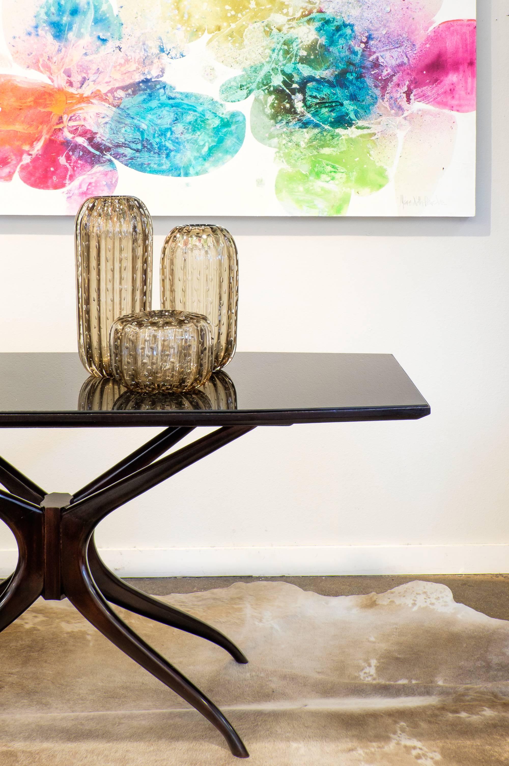 A captivating and sleek Italian midcentury table in the manner of Ico Parisi. This rich and gorgeous rosewood piece has a cobalt glass top supported by sculptural organic polished legs. A modern centerpiece from Italy that elevates any room it is