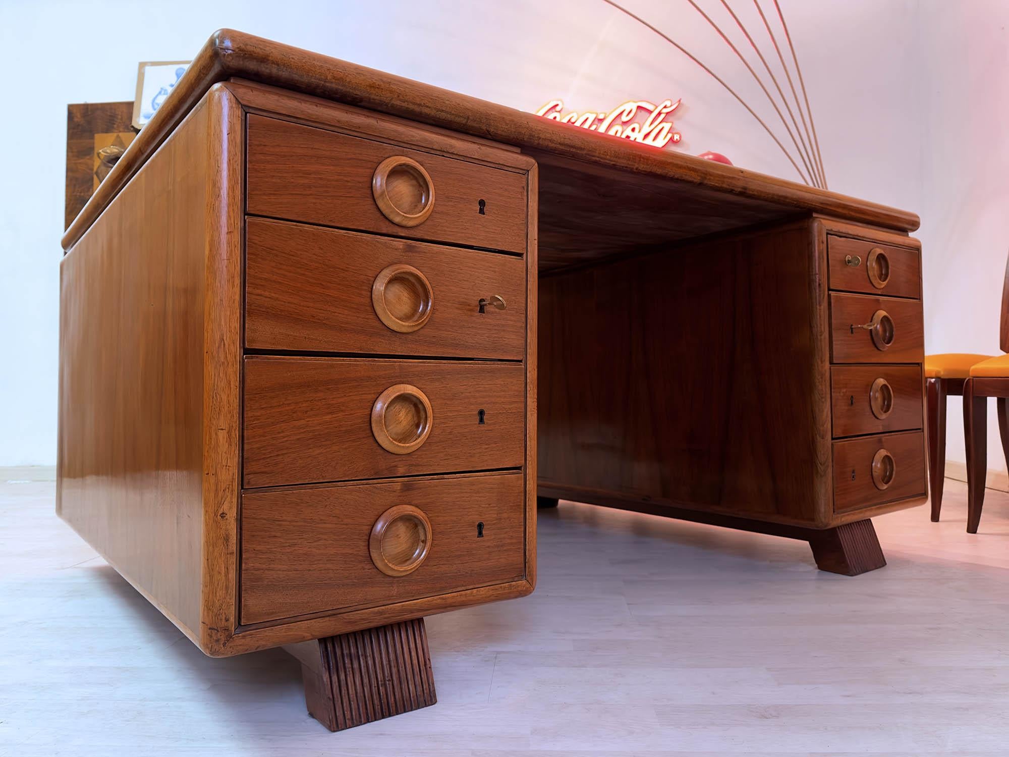 Stunning Italian double-sided desk of the 1950s, attributable to the design of Paolo Buffa.
It’s equipped with eight drawers per side, all lockable, and it’s in very good condition of the period, as all wood surfaces have been recently polished with