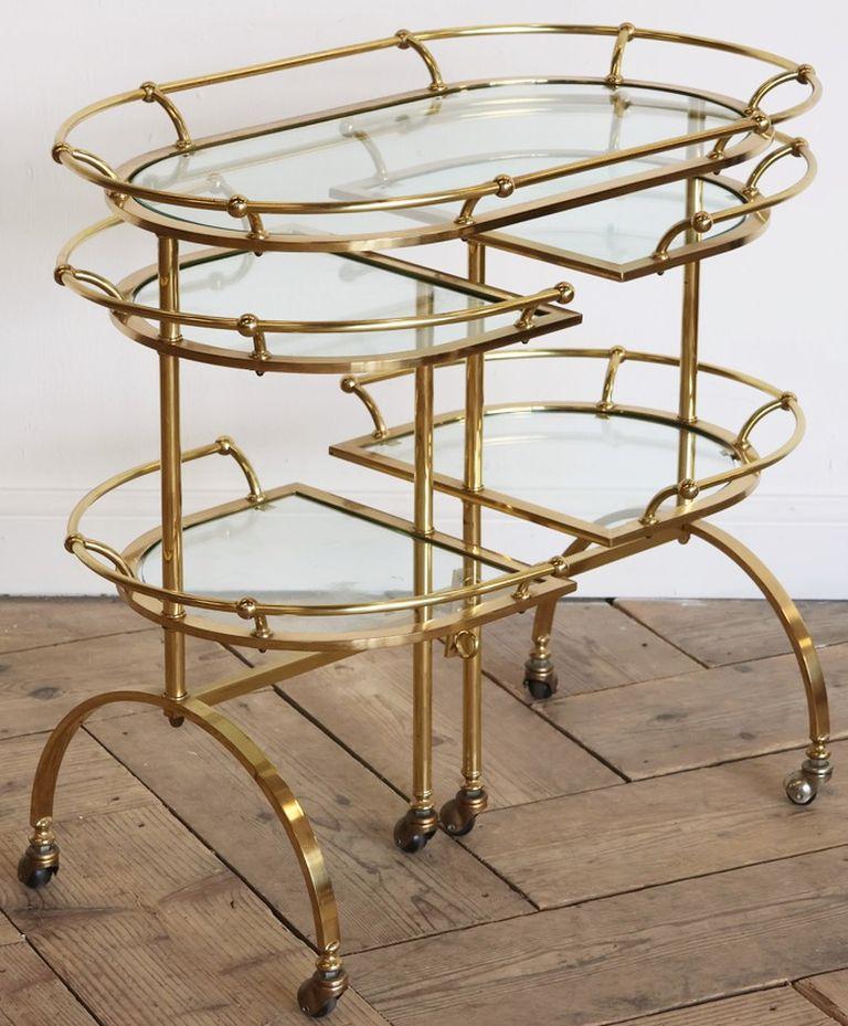 A fine Italian tiered drinks trolley or bar cart of brass and glass, from the Mid-Century Modern era, with turning lower and middle part side extensions, on rolling casters.

Opened - it functions well as a console server.