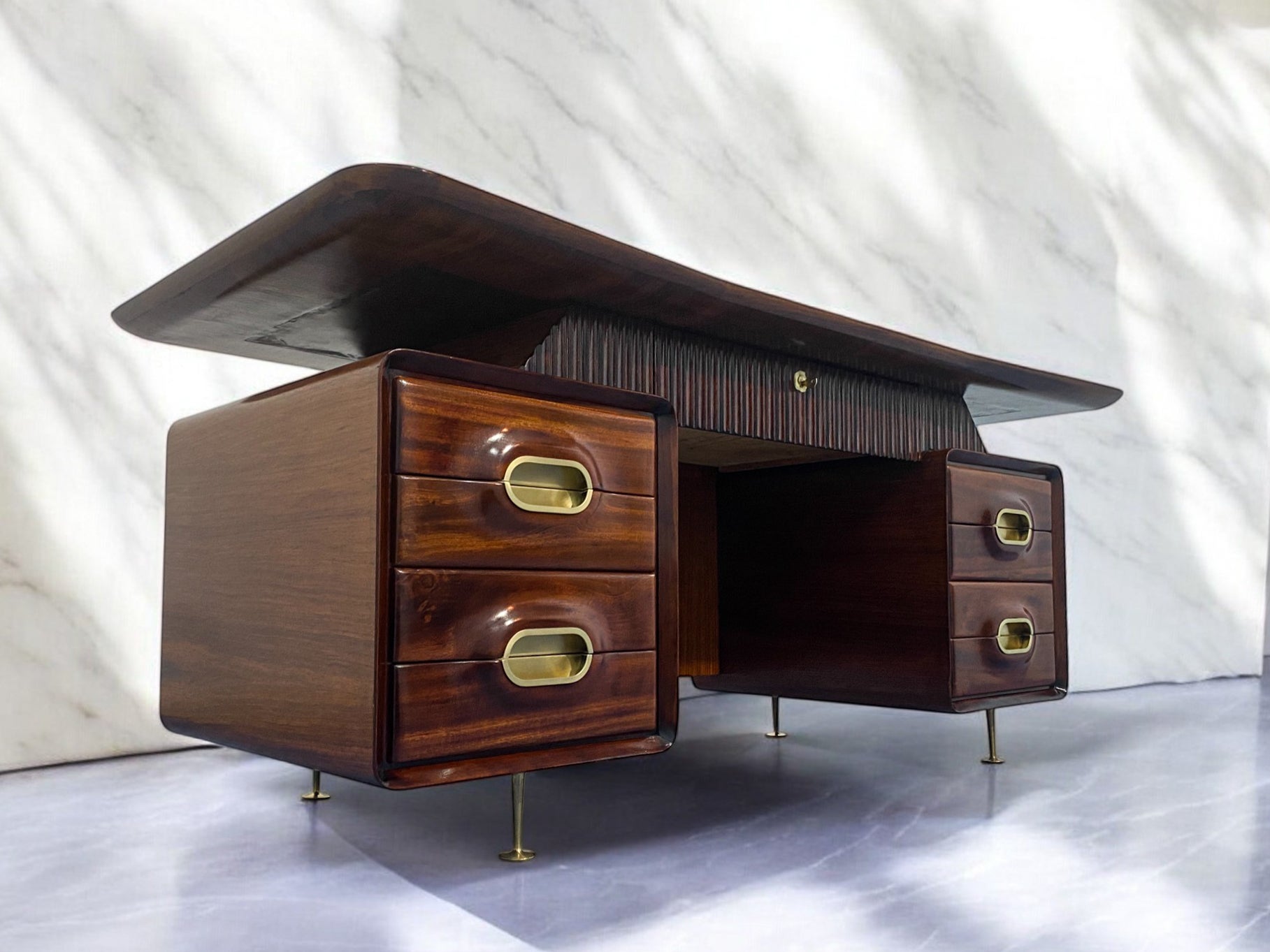 Dieser prächtige Schreibtisch, der in den 1950er Jahren von Vittorio Dassi für Permanente Mobili Cantù entworfen wurde, zeichnet sich durch seine raffinierte Glasplatte mit einer geschwungenen Linie aus. Auf der Vorderseite befindet sich ein