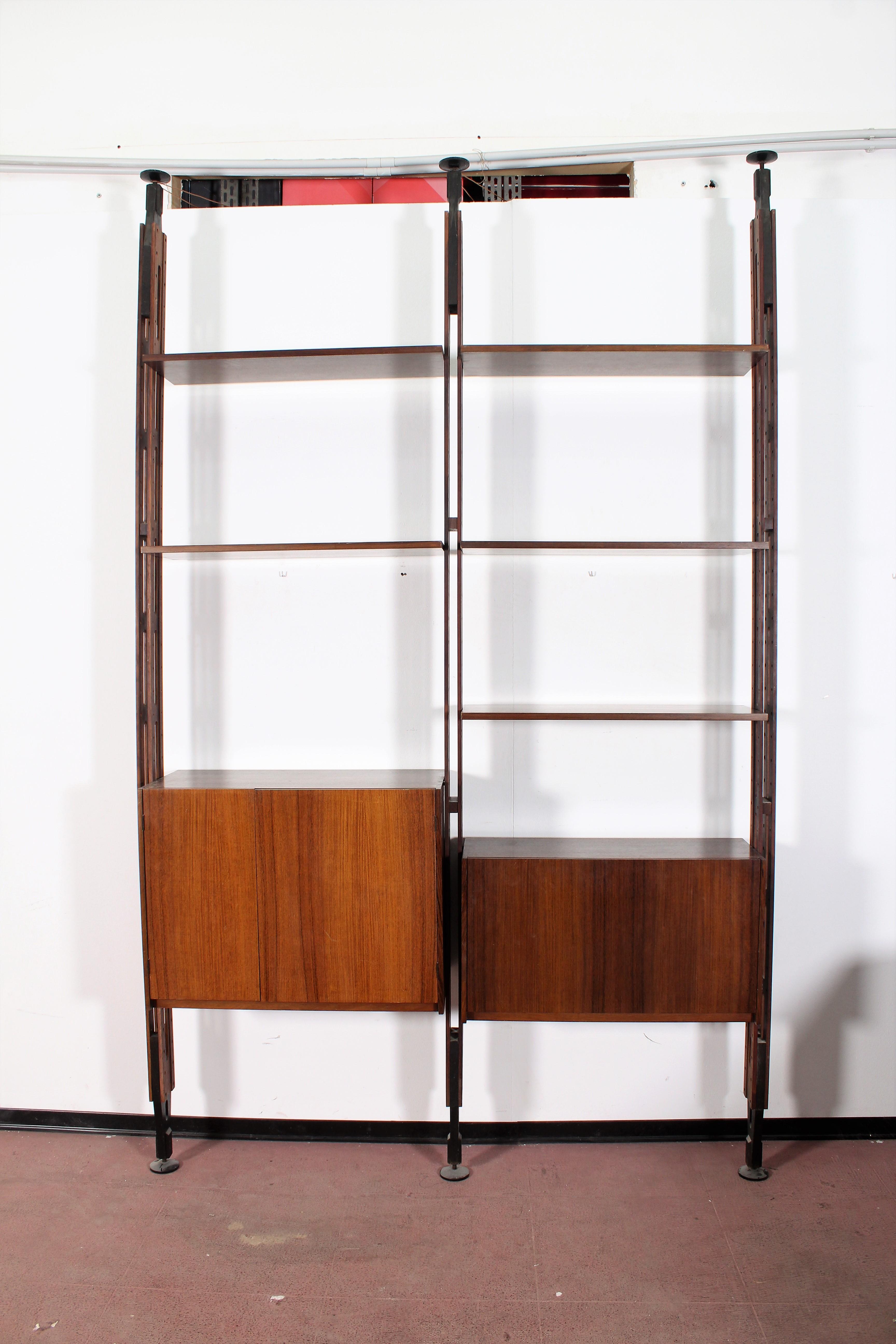 Huge adjustable bookcase with structure fixed to the floor and ceiling, consisting of three uprights five shelves and two furniture. This totally modular system allows to use this group for different shapes. Attributed to Franco Albini, Italy