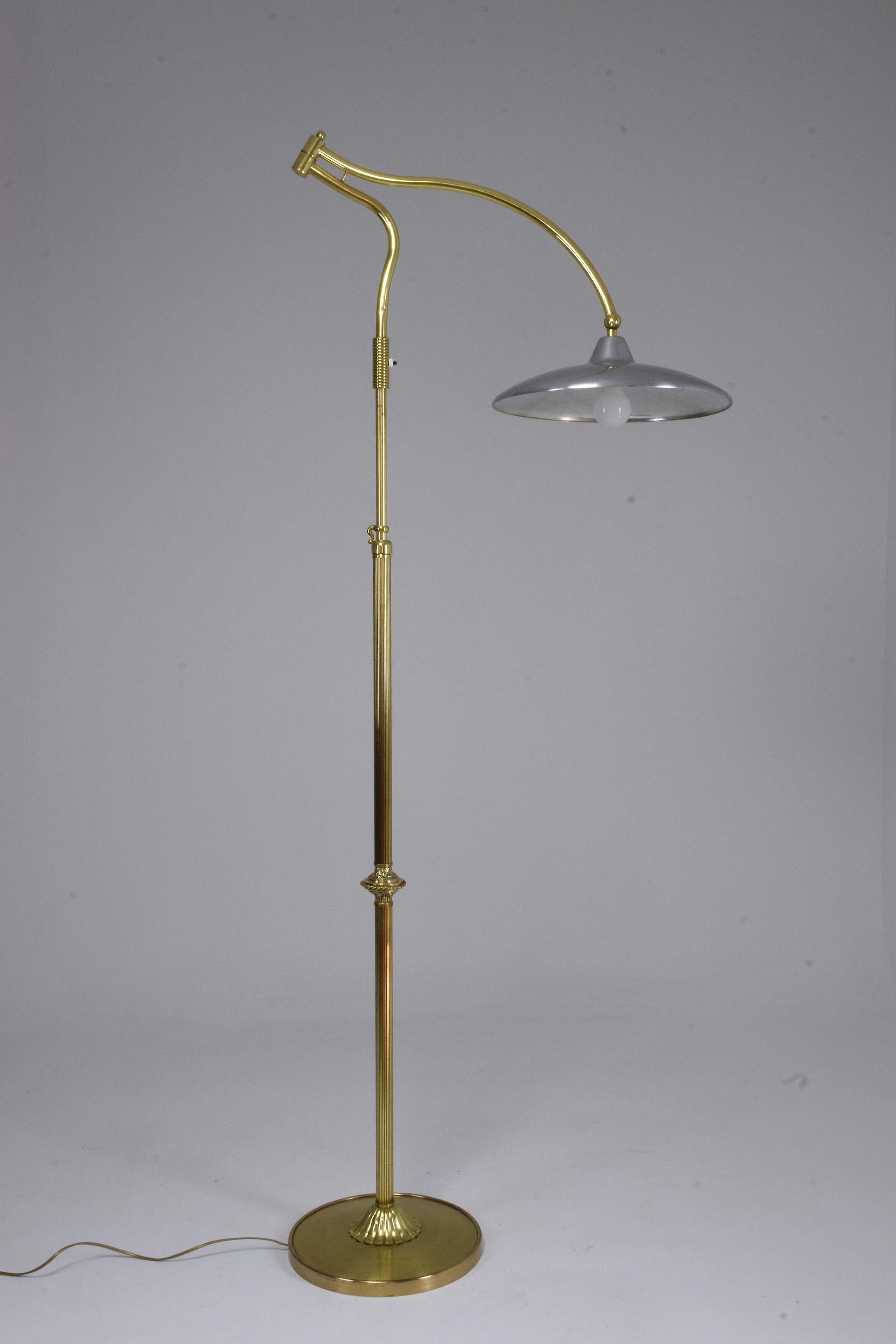 A 20th-century floor lamp manufactured by important Italian manufacturing company Arredoluce in the fifties. This statement light is highlighted by its gold brass structure with molded details and aluminum shade. It is designed with a push-type