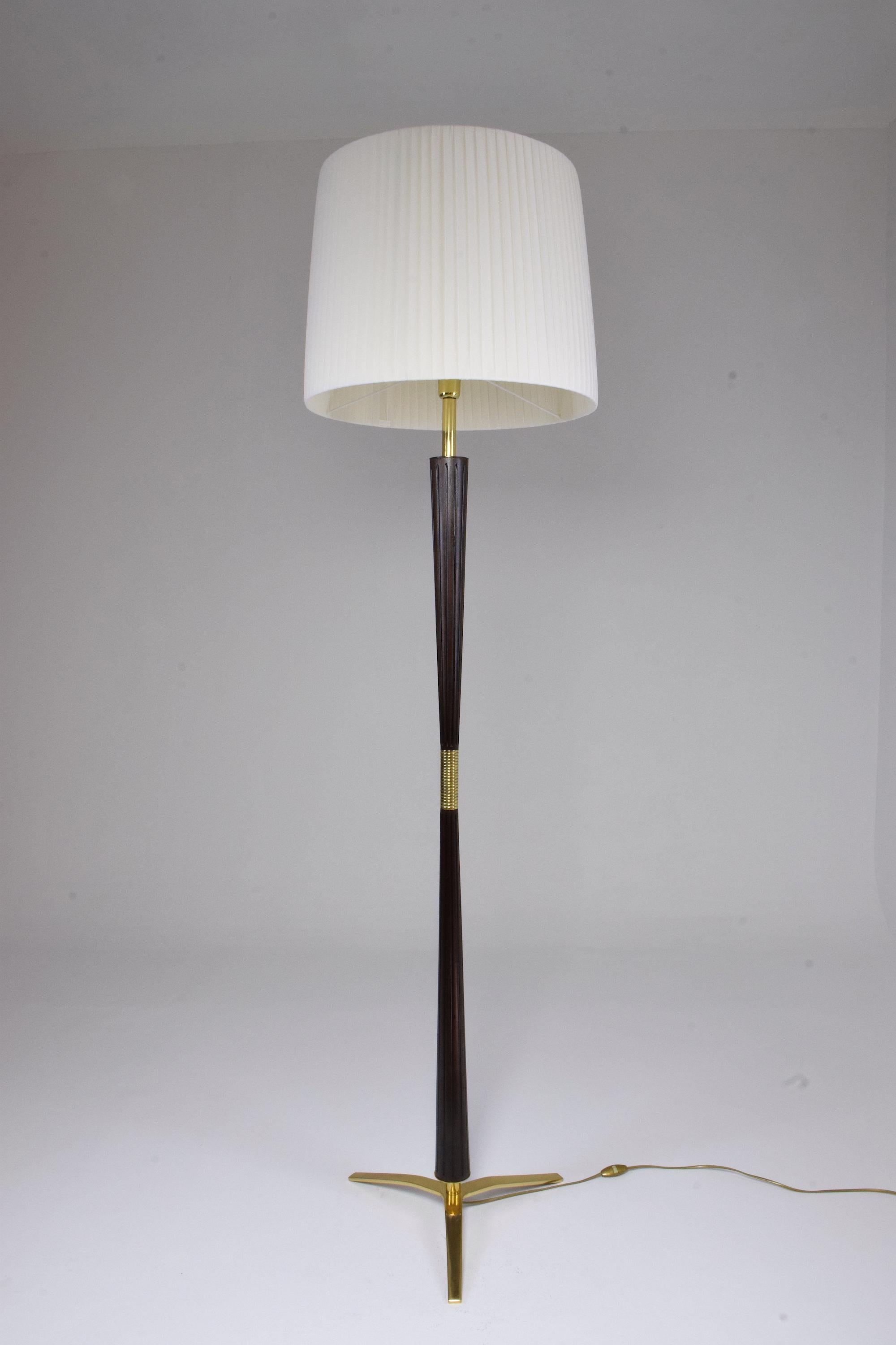 Majestic 20th century vintage floor lamp by notable lighting manufacturing company Stilnovo circa 1950s-1960s designed in solid carved mahogany, brass details, and base.
Professionally rewired and in fully restored condition with a new white soft