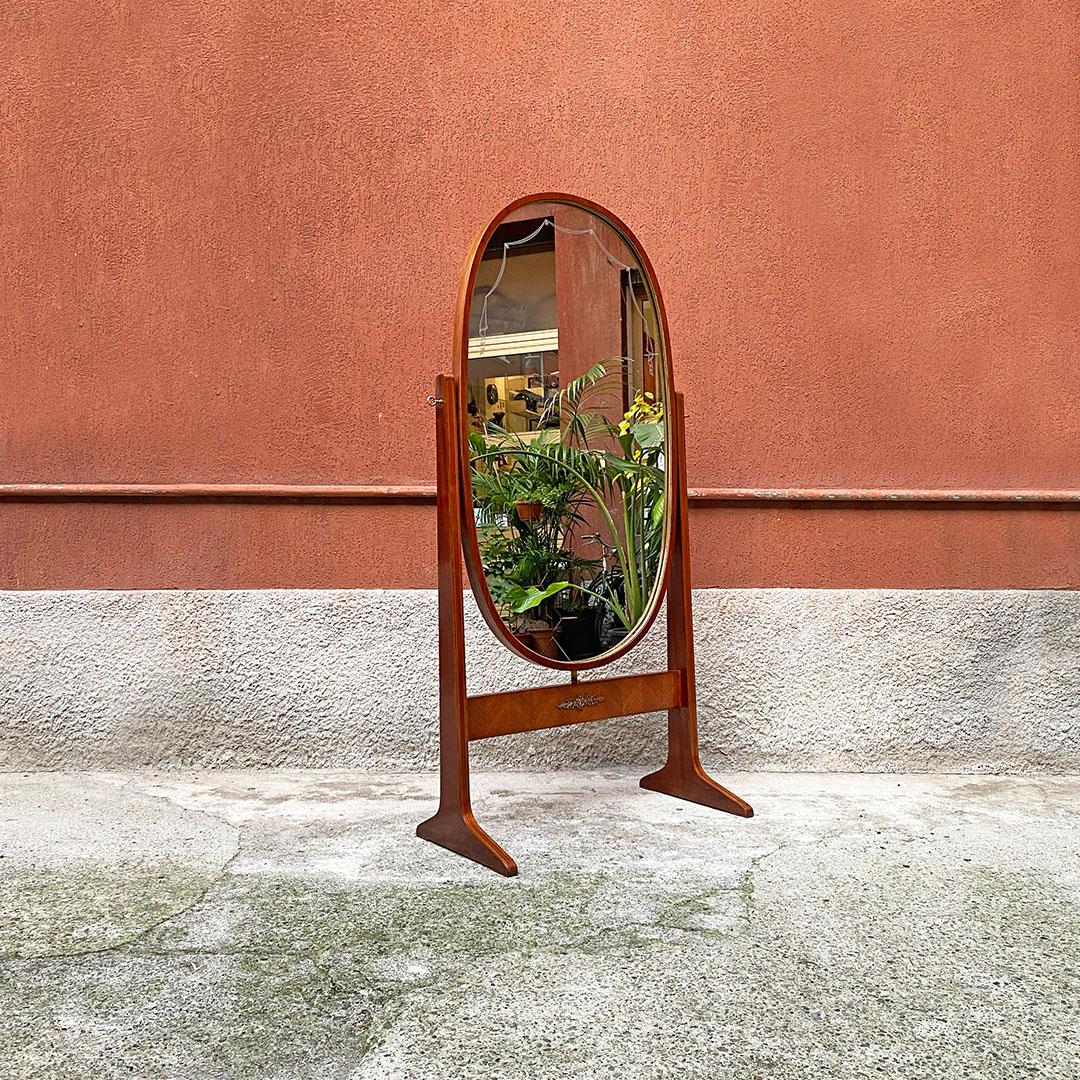 Italian mid century free-standing, full lenght, oval wood floor mirror, 1950s
Free-standing, full-length, oval-shaped floor mirror with structure entirely in wood with decorations both on the frame and on the glass. Brass details on the perimeter,