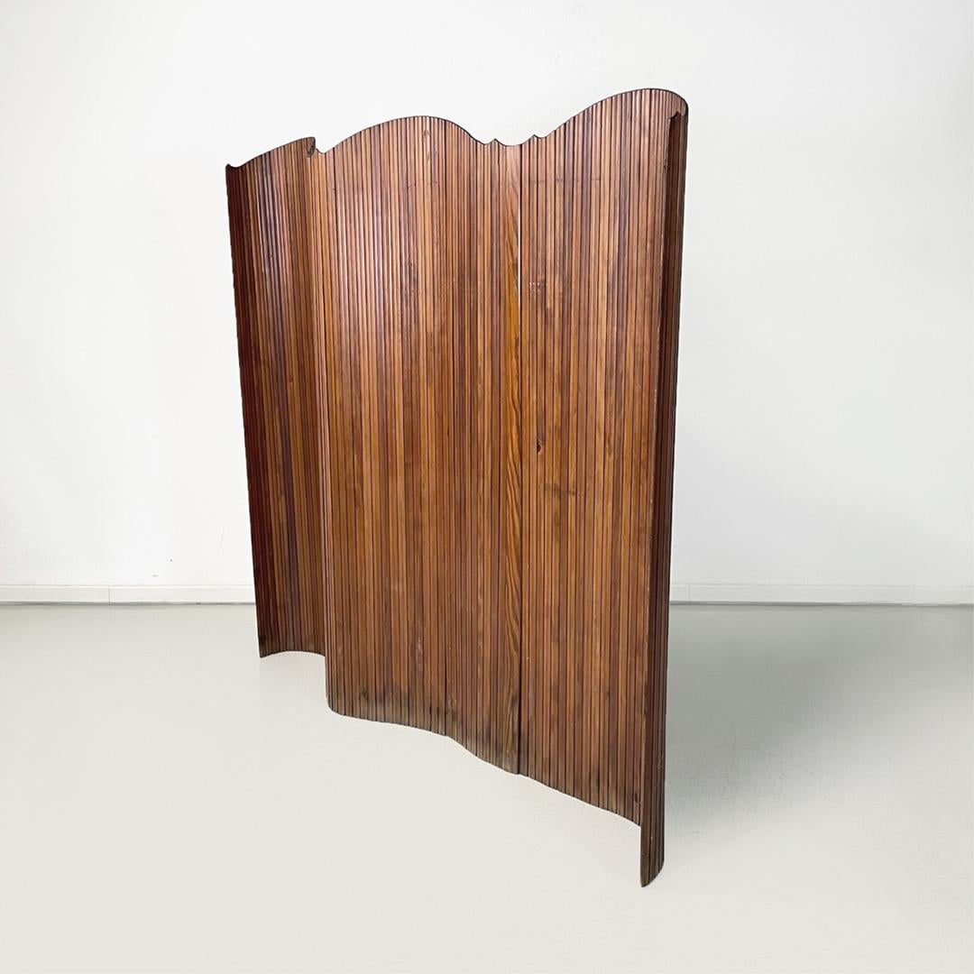 Italian midcentury fully articulated wooden strips screen, 1960s.
Self-supporting and fully articulated screen, made with wood strips. The upper part is geometric and rounded. The structure of the screen can be placed as you desire. It can be used