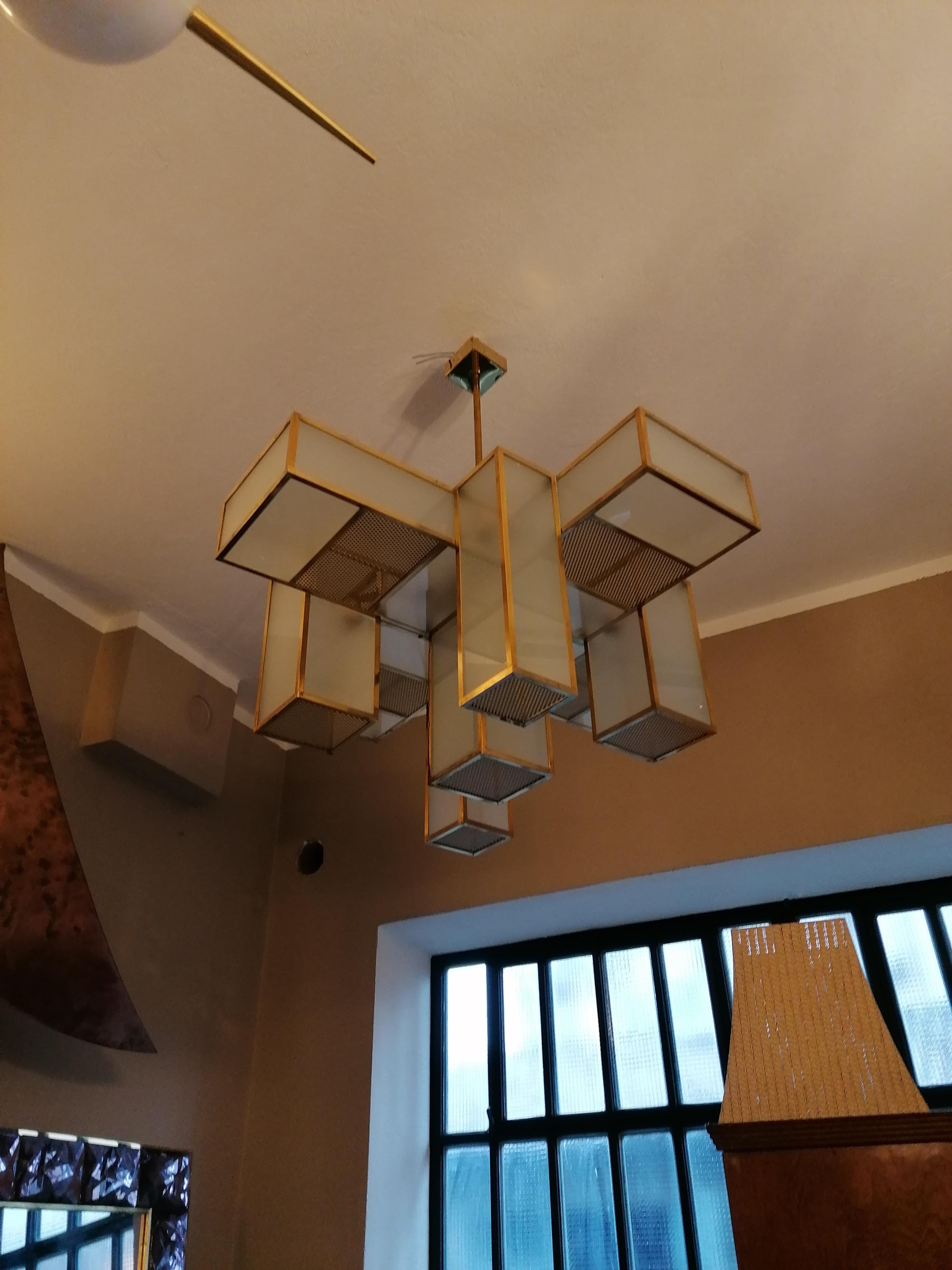 Spectacular huge ceiling lamp in a geometric design with 9 arms in all directions and downwards.
Brass frame with frosted glass.
To replace the bulbs the arms have a grid in the lower erea, which also increases the light failure. 
Original condtion,
