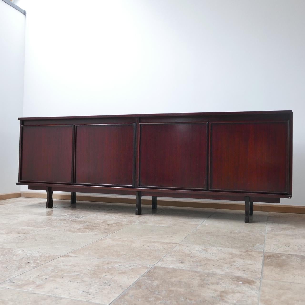 Italian, midcentury sideboard.

circa 1960s, by Giovanni Ausenda for Stilwood.

Rosewood veneer.

Some wear but generally good condition.

Dimensions: 53 D x 214 W x 74.5 H in cm.
 