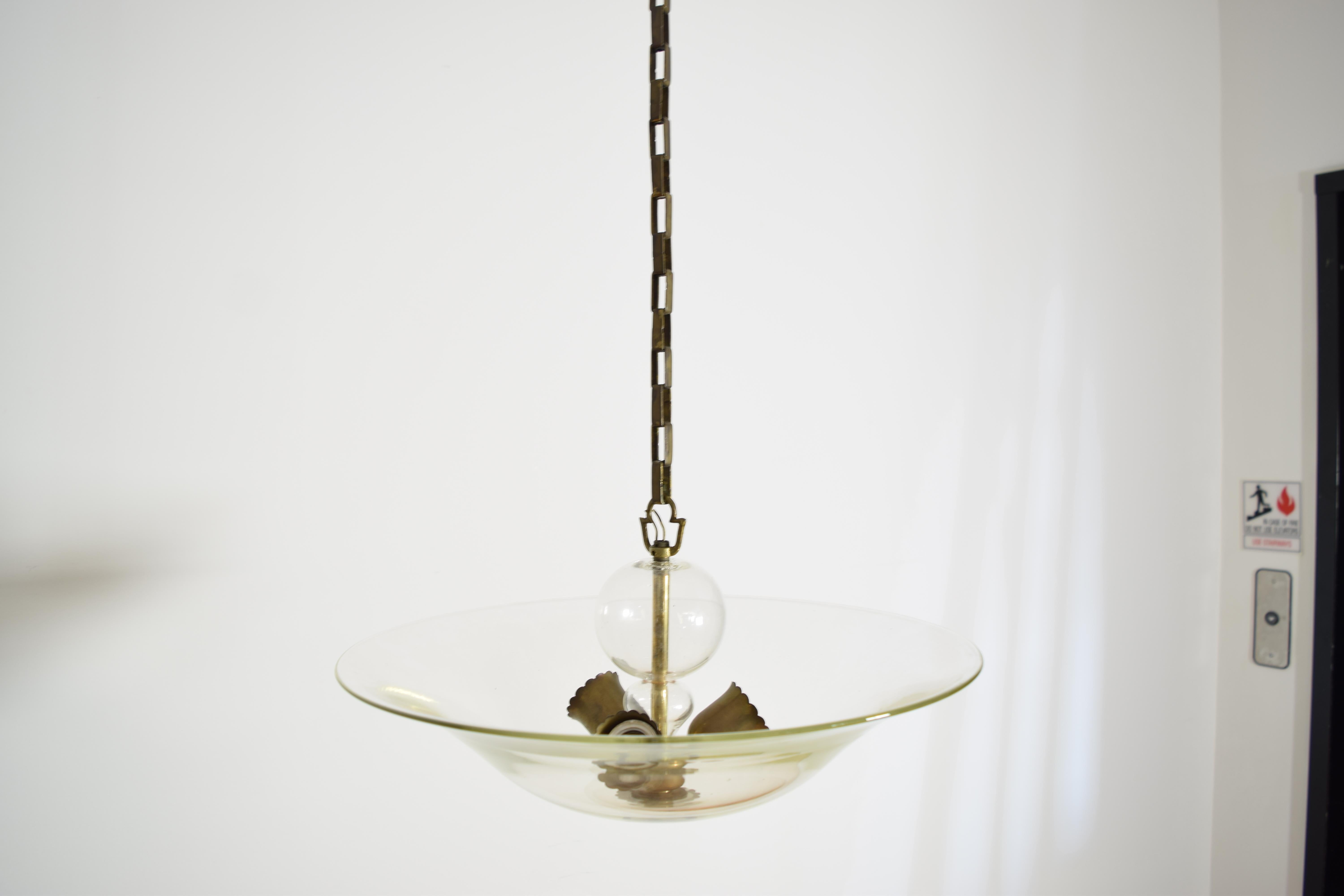 having a glass bowl with a three-light brass cluster within, a blown glass ball above, with 17