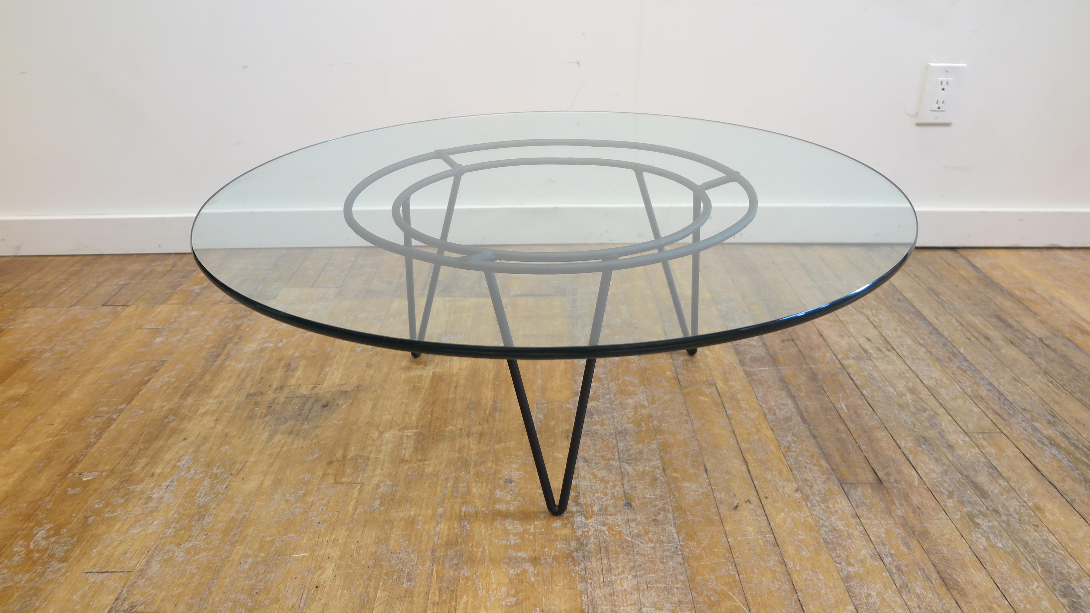 Italian mid-century modern Iron and glass round cocktail table. Round low glass cocktail table set on studio iron base. The table is in good condition some scratches to the glass not detracting. Iron base has been repainted. Very good condition,