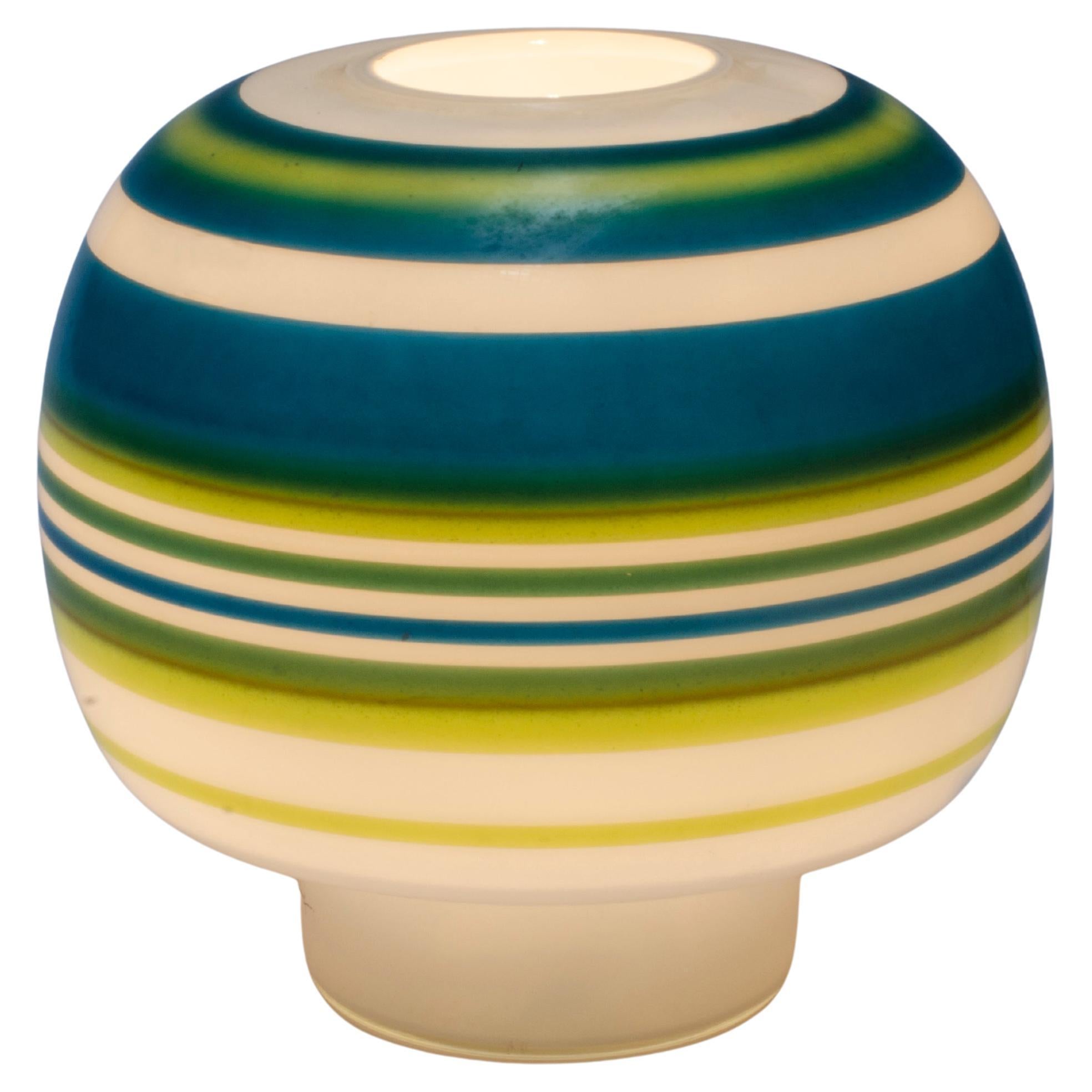 Mid-century modern table lamp, made of white glass with blue and green hues.

Italy, circa 1950.