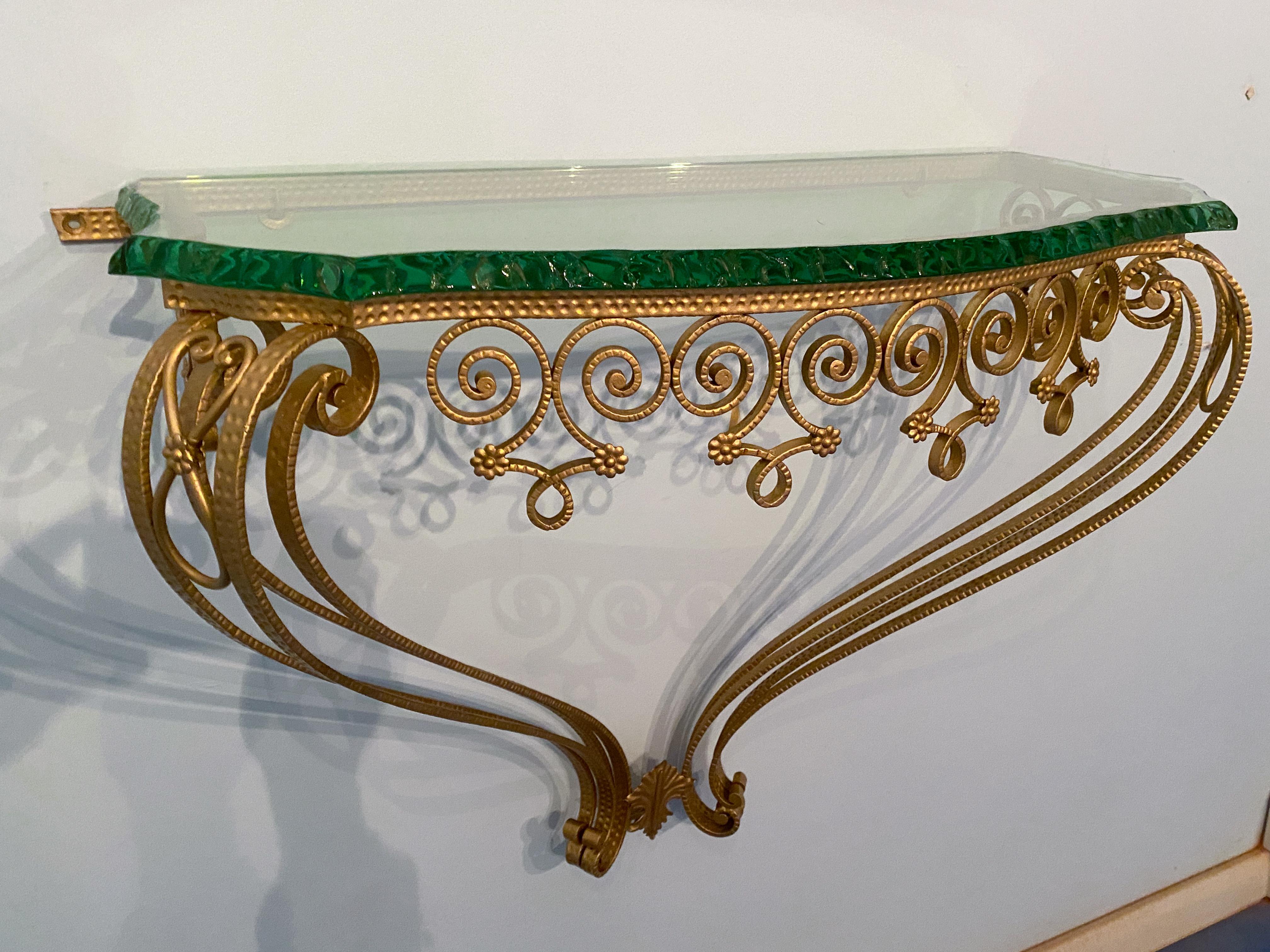 This magnificent console, designed in the 1950s by Pierluigi Colli, is a work of art distinguished by its high-quality craftsmanship in handcrafted metalwork. The thick green crystal top was cut by hand with special pliers to make it unique, making
