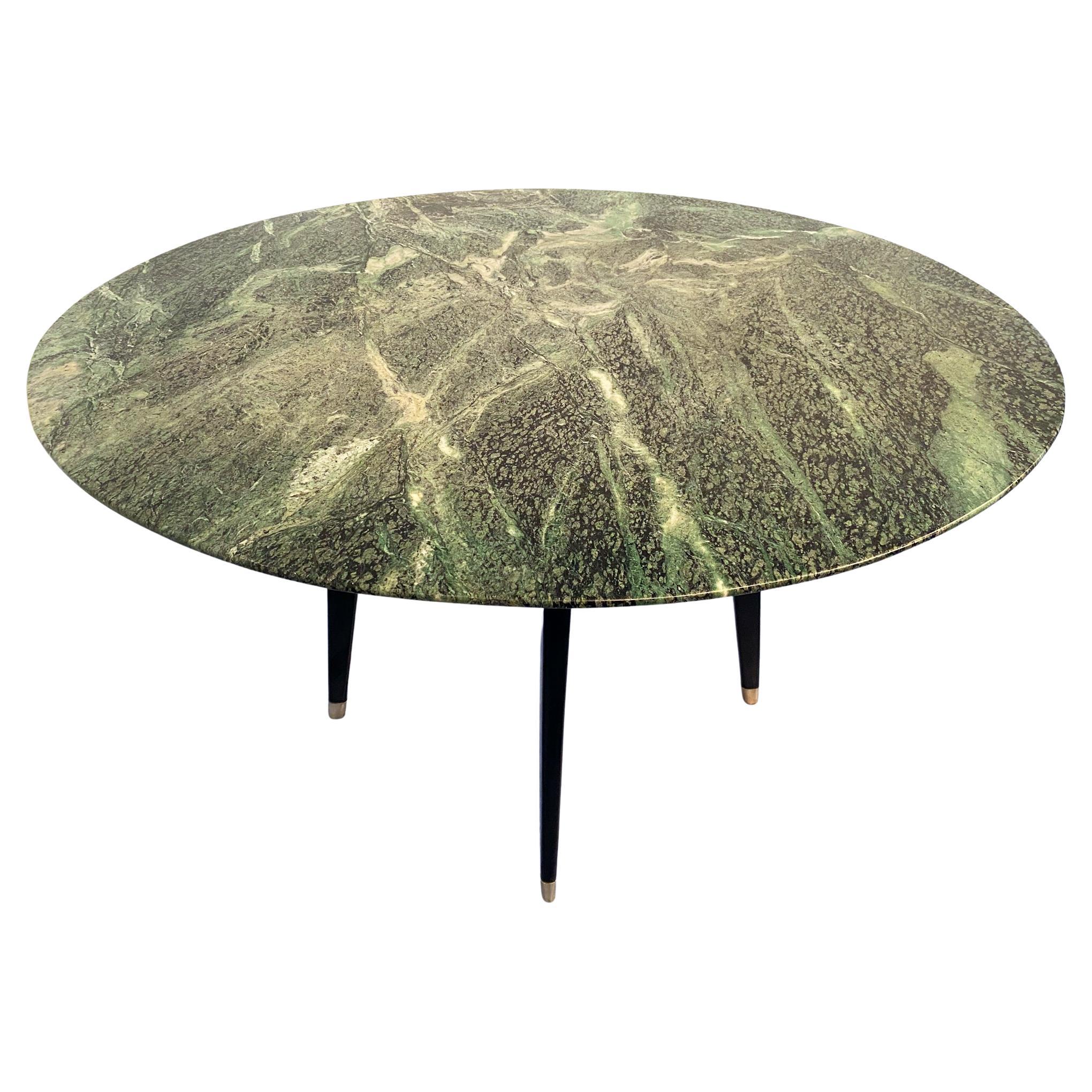 This stylish mid-century round marble support or center table is a stunning example of 1950s Italian design. The top is crafted from precious green marble from the Alps. The black lacquered walnut base, the original cross support at the center, and
