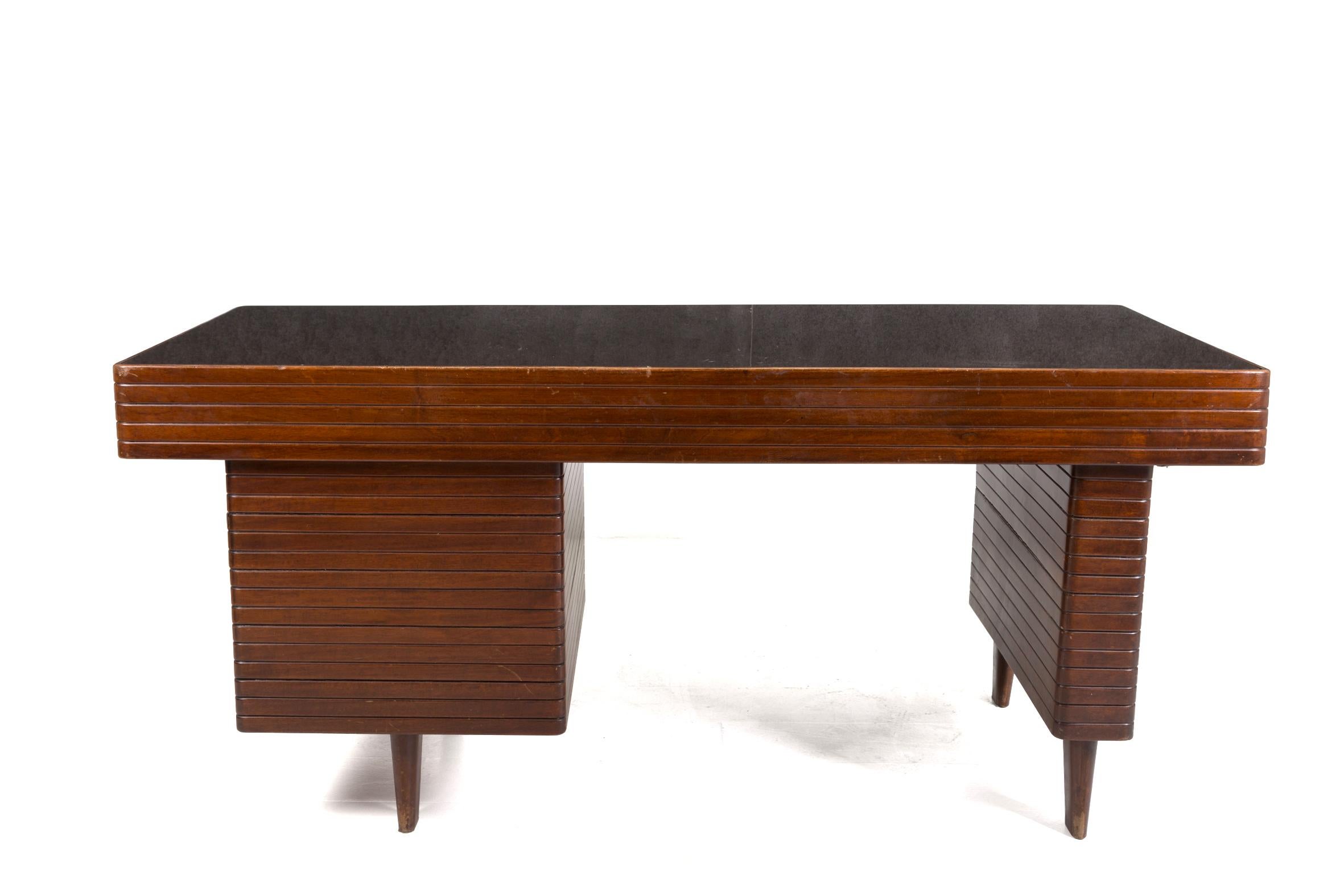 Magnificent desk attributed to Gio Ponti of the 1950s. The desk is made of walnut wood grissinatura. It has been attributed to the great Italian designer because of its realization and its typical lines. The desk has a dark colored glass top that