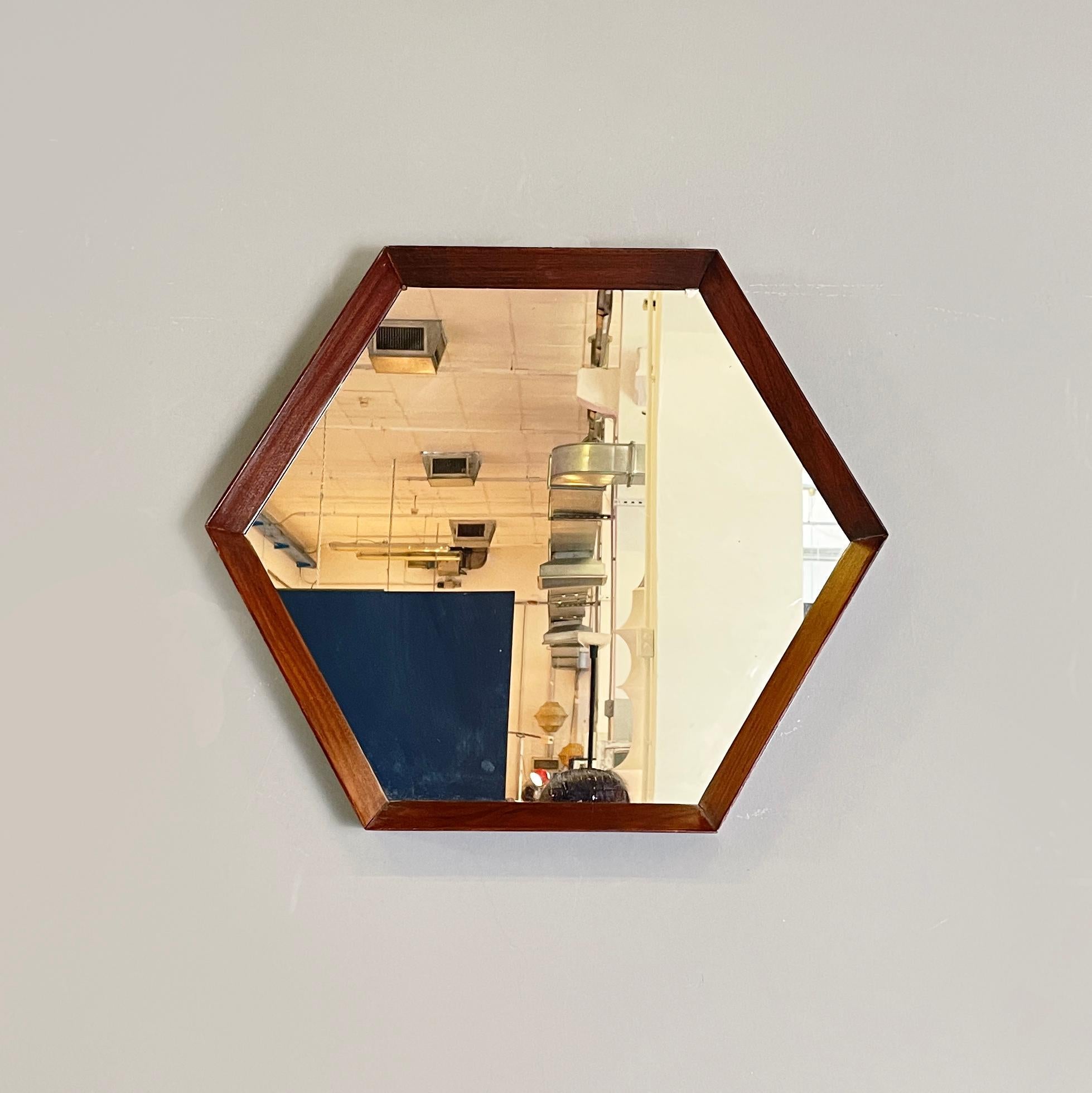 Italian mid-century Hexagonal wall mirror with wooden frame, 1960s
Hexagonal shaped wall mirror with thick wooden frame. The frame is made up of 6 dark solid wood strips. At the top there is a triangular metal hook for hanging.
It came from 1960