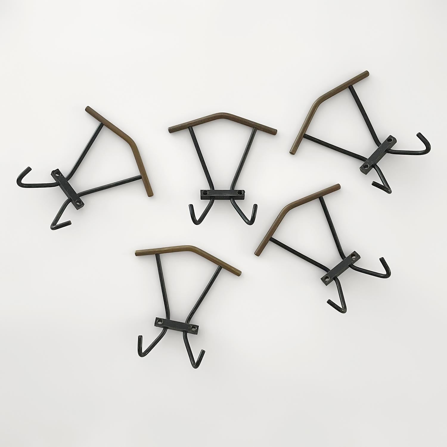 Italian iron coat hooks
Italy, 1960s
Beautifully contrasted black lacquered metal with angled brass upper piece creates a palette to please    
Each wall mounted hook is supported by a bracket which requires two screws
Bottom portion has two petite