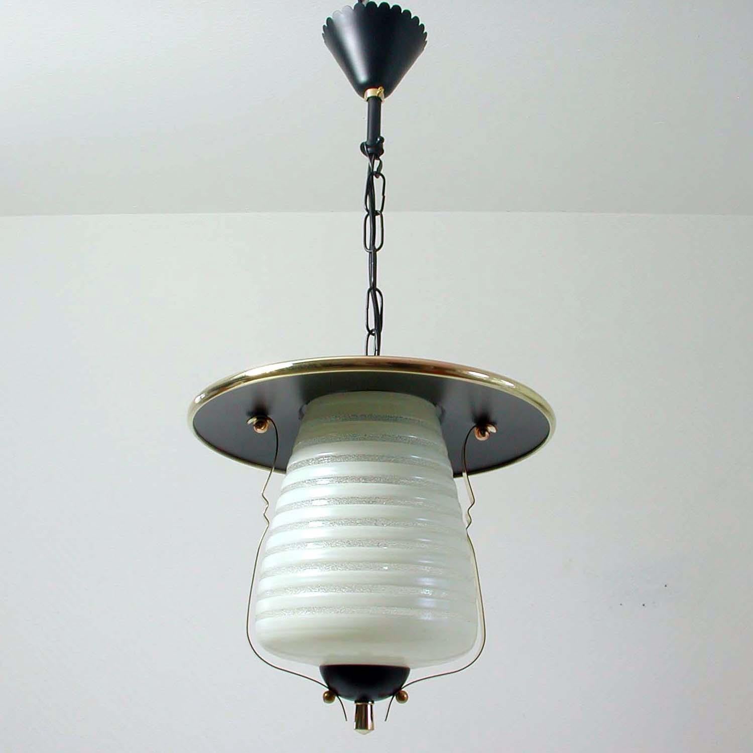 This vintage lantern ceiling light was made in Italy in the 1950s. It is made of black lacquered metal, frosted glass and has got brass details.
 