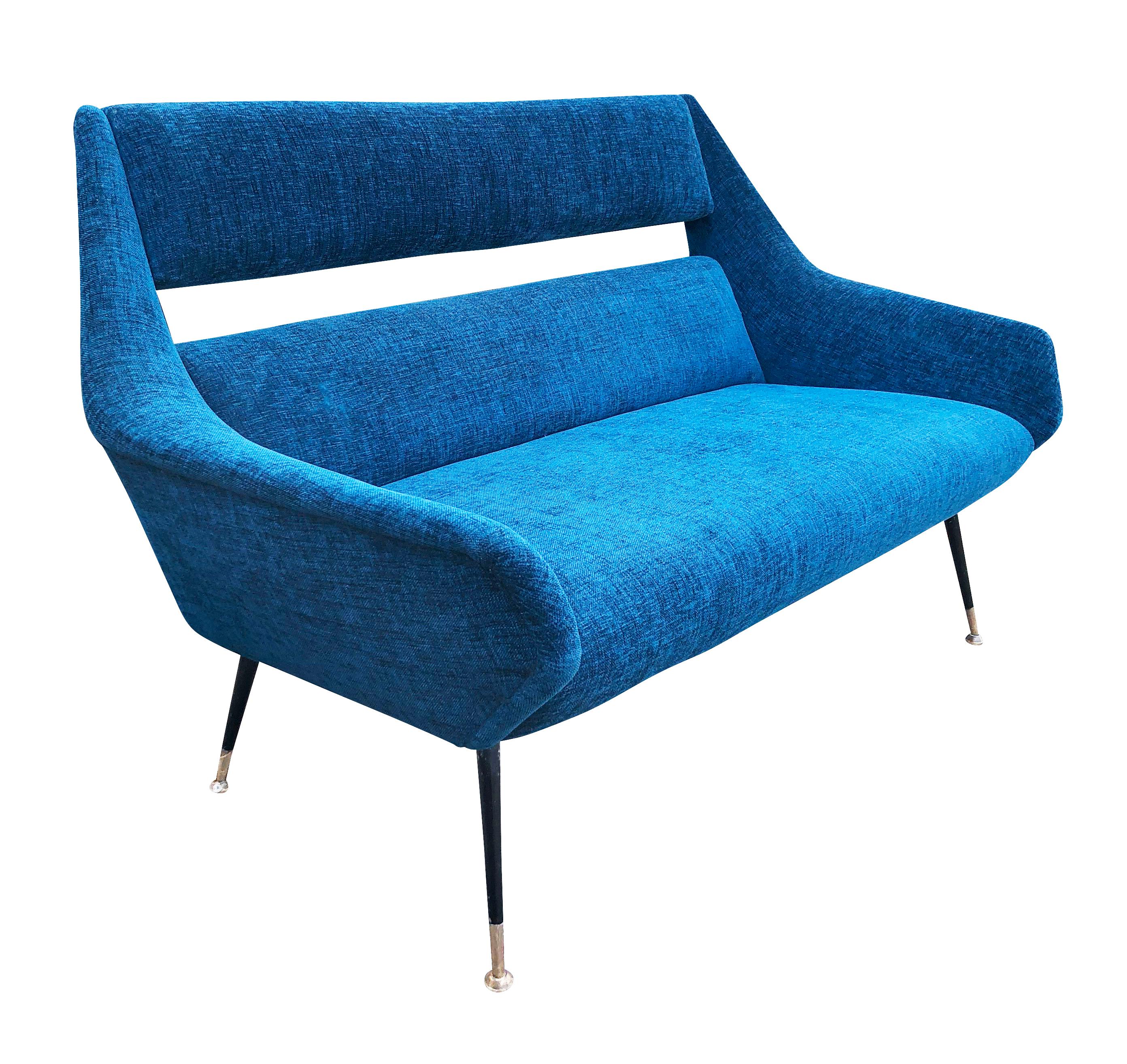Midcentury loveseat by Gigi Radice for Minotti. An iconic design with the very recognizable slit back and brass lags. Recovered in a blue fabric. Two lounge chairs from the same set also available.

Condition: Minor wear consistent with age and