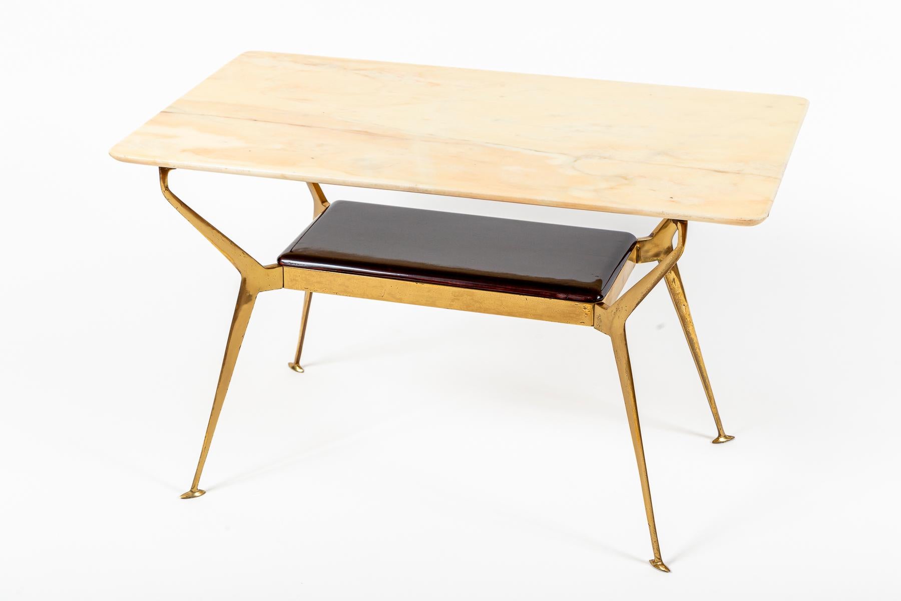 Un maravilloso y único bronce esculpido y angular de dos niveles de mediados de siglo  base de mesa perfilada que mantiene su meseta original de ónice y se muestra con un palisandro lacado pulido de nuevo  estante inferior.

Encimera de mármol ónix