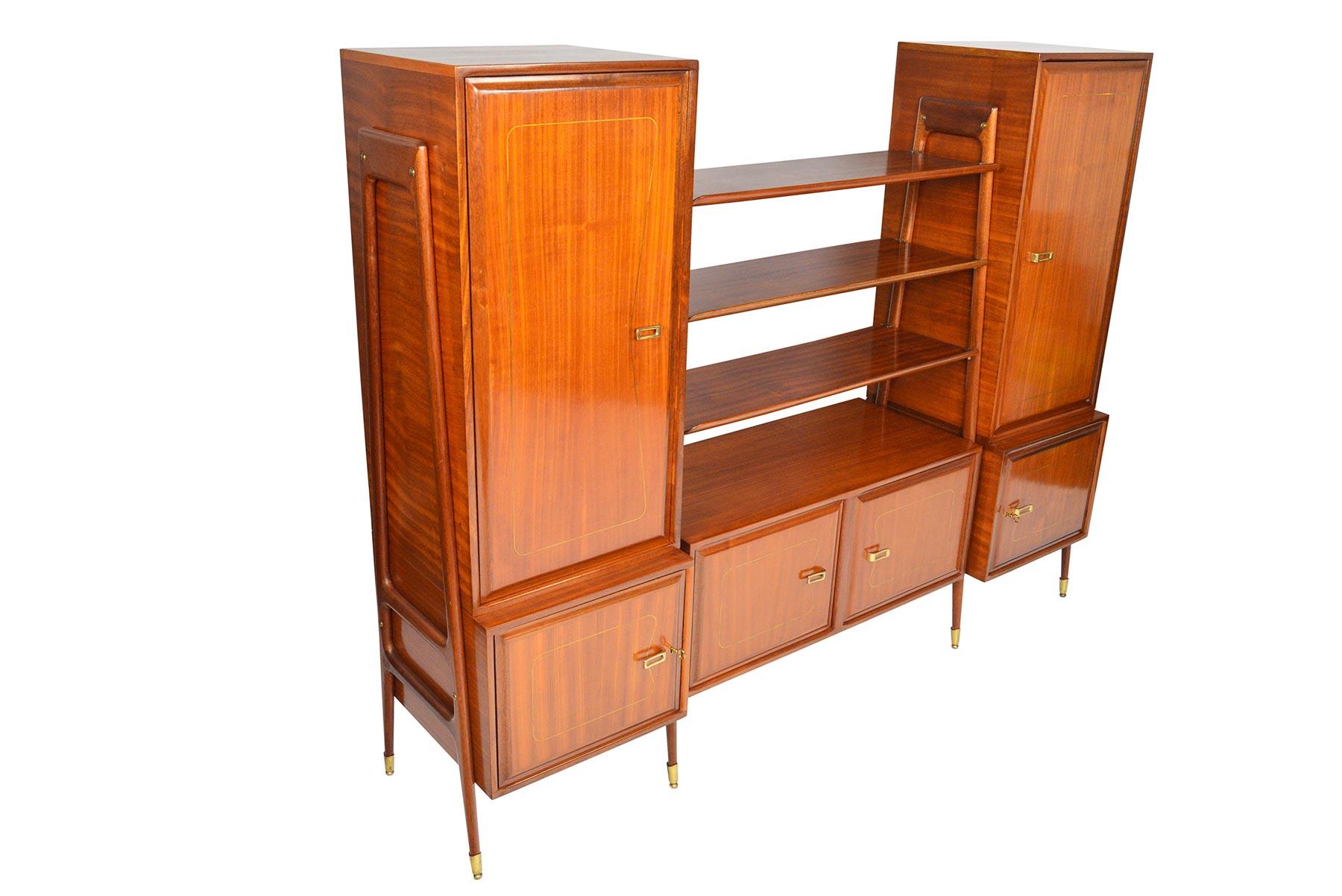 Designed in the 1960s in Italy, this bold and beautiful mahogany bookcase credenza offers exceptional craftsmanship and understated details. Brilliant brass inlays surround each door panel. Two tall cabinets, three smaller cabinets, and three
