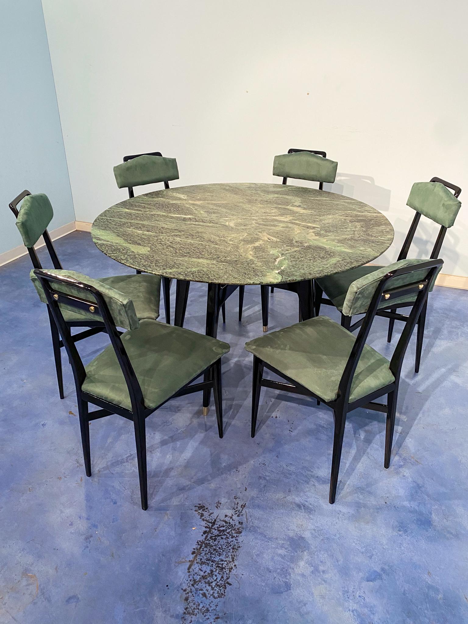 This stylish mid-century round marble center table is a stunning example of 1950s Italian design. The top is crafted from precious green marble from the Alps. The black lacquered walnut base, the original cross support at the center, and refined