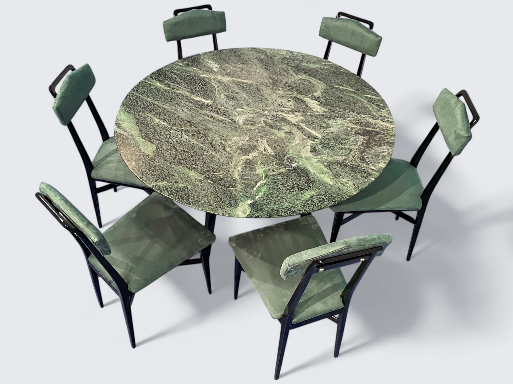 This stylish mid-century round marble center table is a stunning example of 1950s Italian design. The top is crafted from precious green marble from the Alps. The black lacquered walnut base, the original cross support at the center, and refined