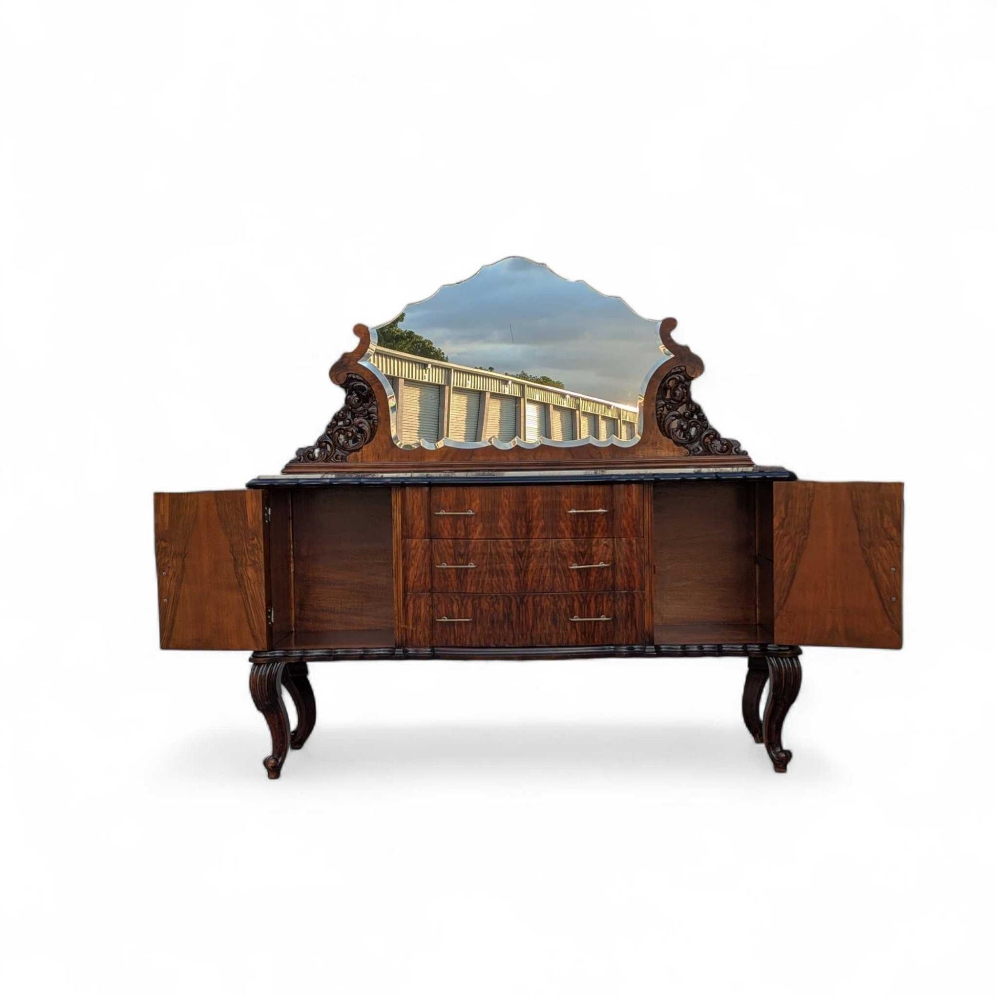 An elegant Italian Mid-Century sideboard by Mobilificio Scorza Ovada, featuring a luxurious marble top, rich burl wood veneer, and dark lacquered accents. This sophisticated piece includes two cabinet doors and three central drawers with stylish