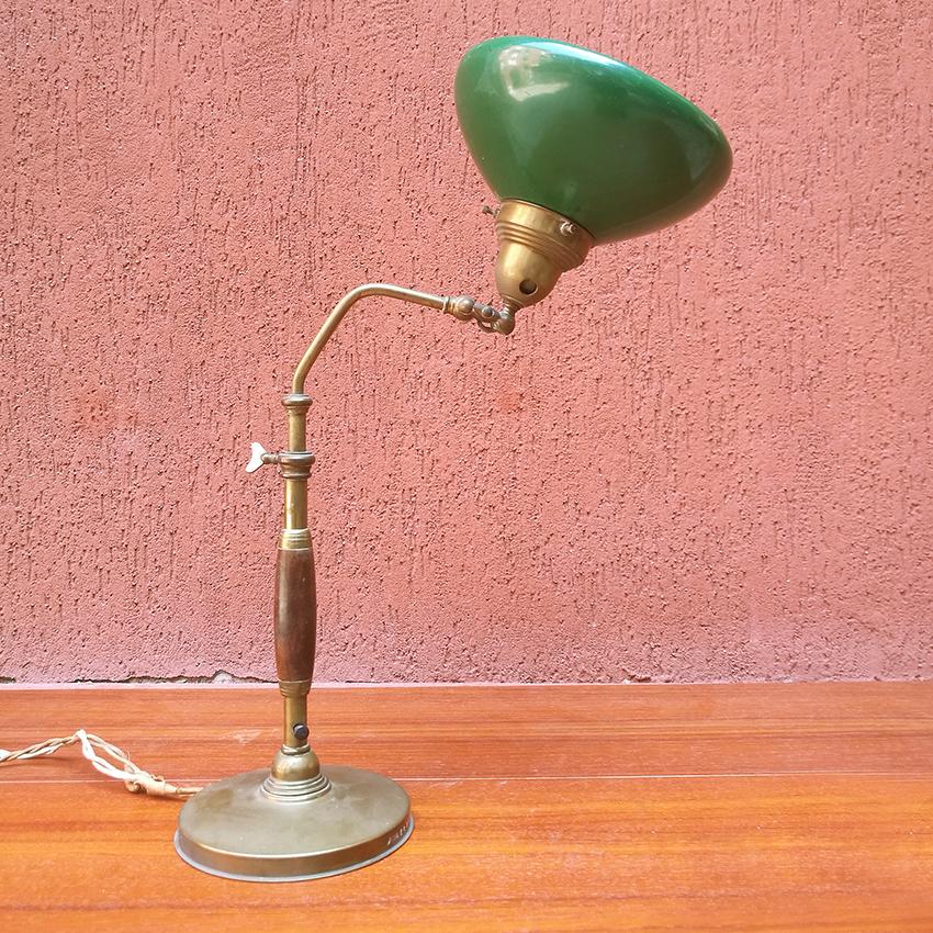 Lampada da tavolo ministeriale italiana del Medioevo in legno e metallo, anni '20
Magnifica lampada direzionale, rappresentativa dello stile degli anni '20, con stelo in legno e metallo e paralume regolabile in metallo smaltato verde.
Buone