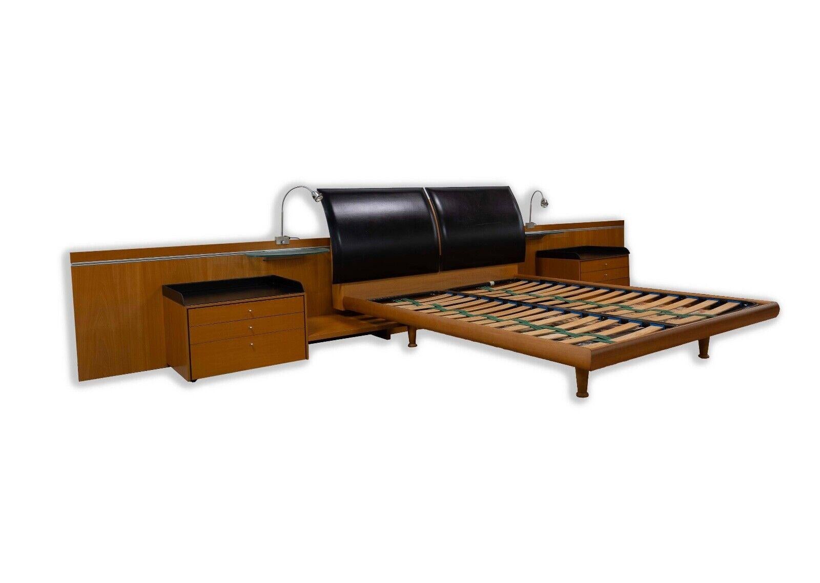 Experience the epitome of mid-century modern charm with this Danish-inspired Queen Sized Platform Bed, complete with attached side tables and lamps. Crafted with attention to detail, the bed seamlessly integrates minimalist design and functionality,