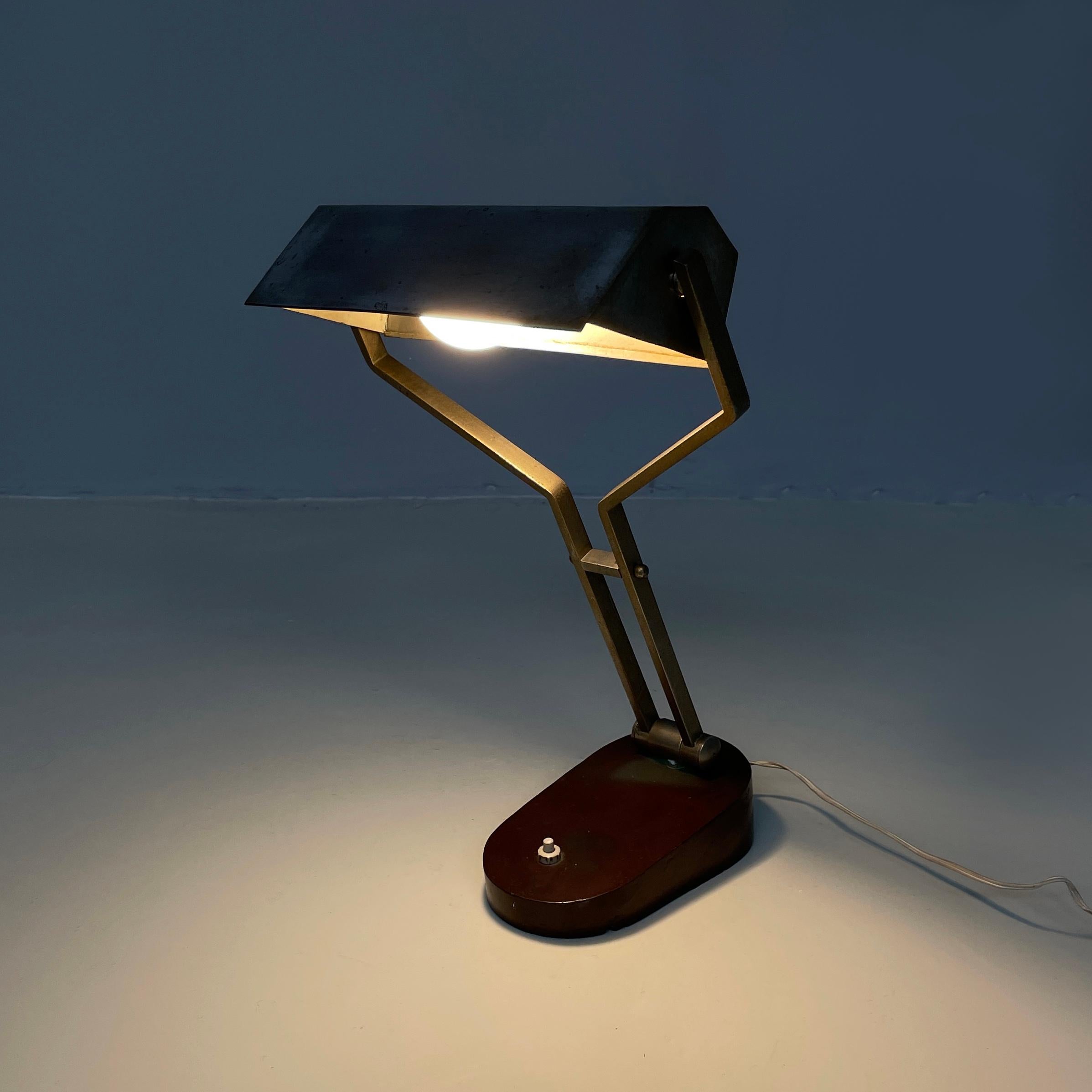Lampada da scrivania o da tavolo regolabile in metallo marrone, anni '30.
Lampada da tavolo o da scrivania con base ovale in metallo verniciato marrone. Il paralume con base rettangolare in metallo è regolabile. La struttura regolabile è composta da