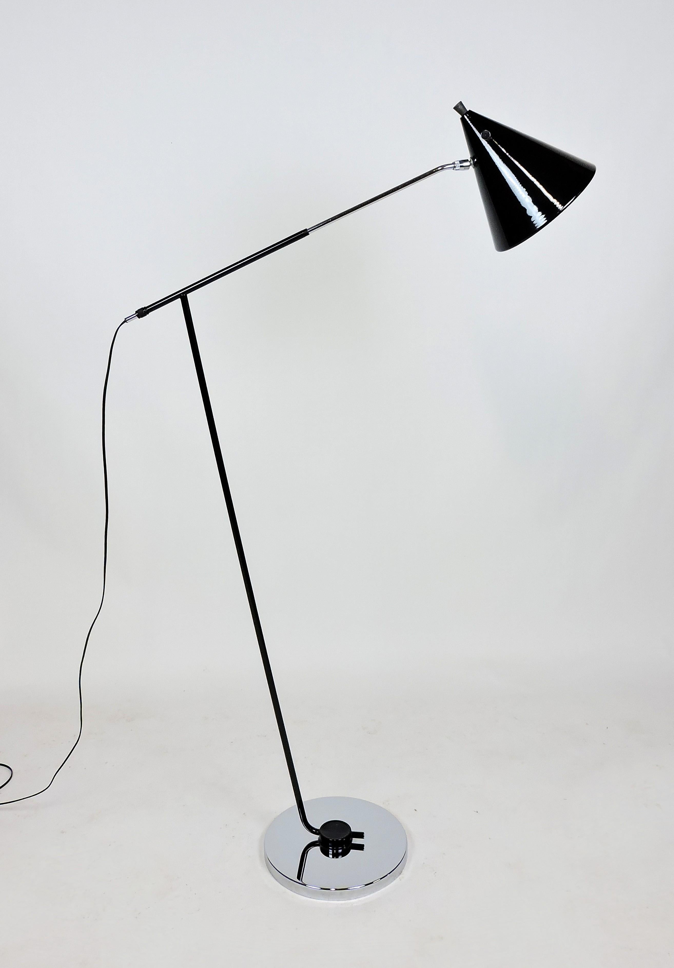 Beautiful mid century Italian modern floor lamp with an adjustable arm. This stylish lamp is made of shiny chrome and black lacquer with an arm that can be adjusted in length and a shade that can pivot to adjust the angle. All new electrical wire