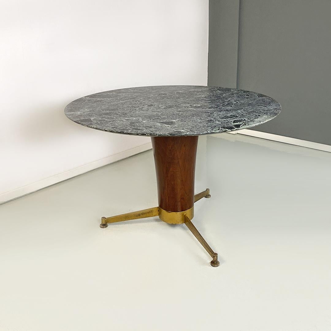 Italian Mid-Century Modern Alpi marble, wood and brass round dining table, 1950s.
Dining table with green Alpi marble top, with structure with central part in solid wood and legs with three support spokes and adjustable brass tips.
The green alps