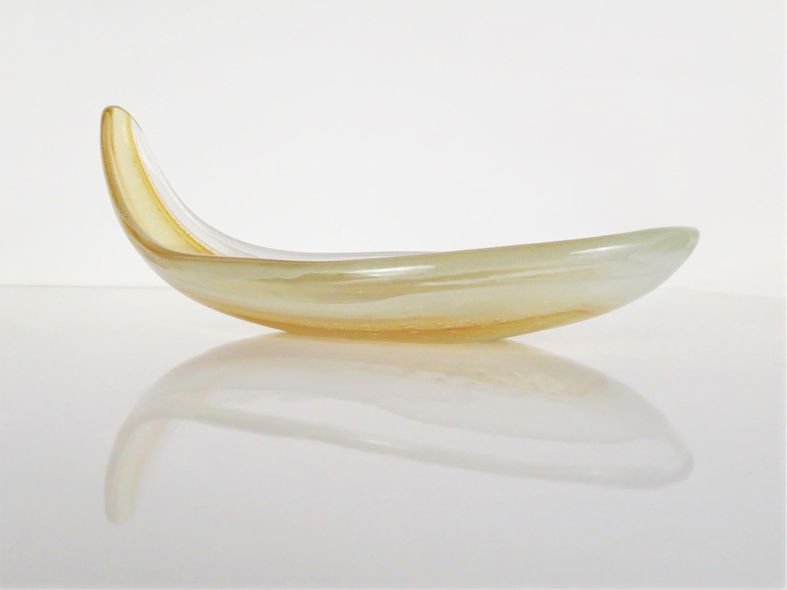 Lovely, elongated glass Murano shallow bowl in clear with infused gold by Seguso, Italy. Reminiscent of a very elegant summer squash with a handle.

Measurements: 12 inches wide x 5 3/4 inches wide x 5 inches high

Very Good Condition. The upper