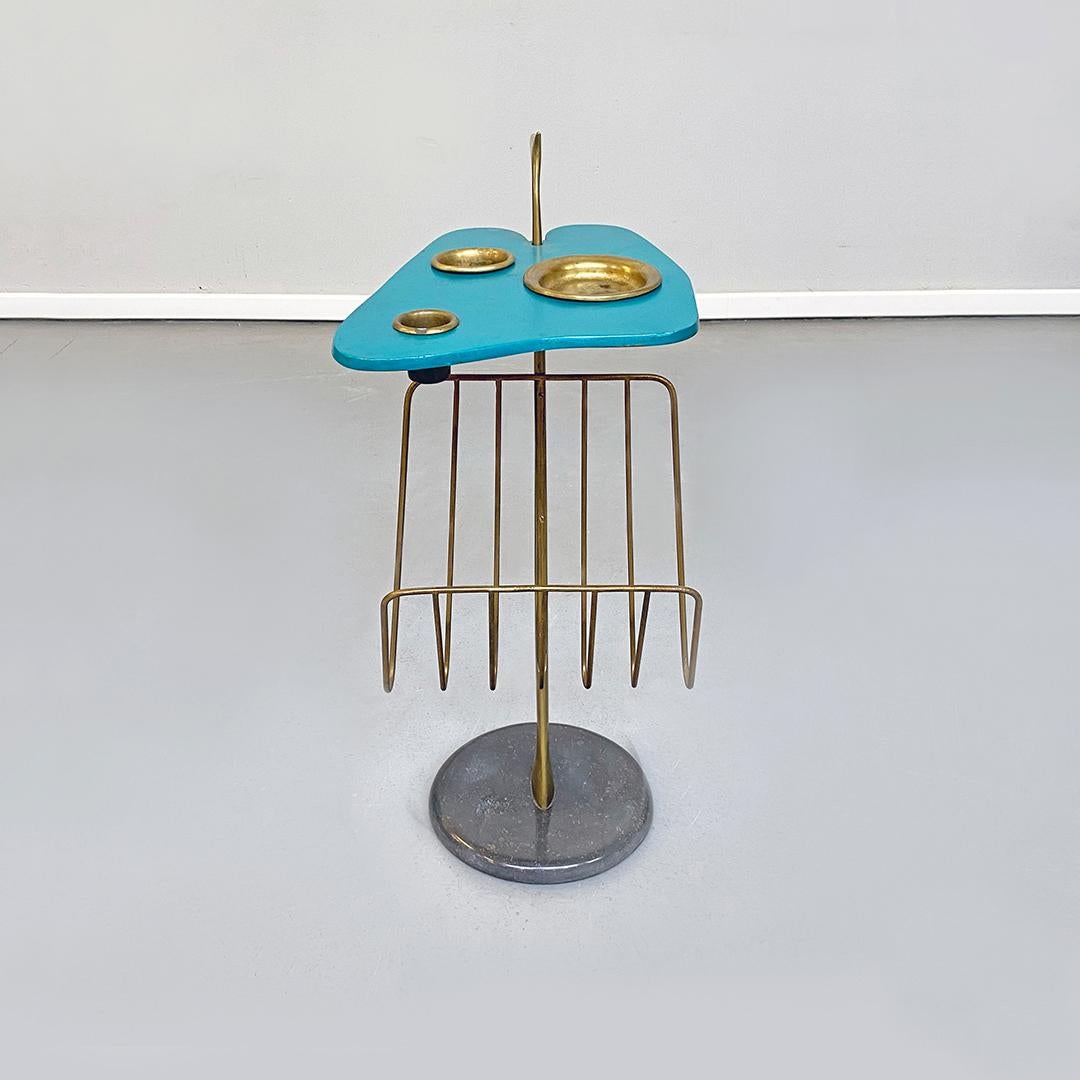 Italian Mid-Century Modern aqua green magazine rack with brass detail, 1980s
Aqua green magazine rack with flat surface in teal painted metal in original color, with irregular shape and trio of brass ashtrays, housed on the same floor. Central