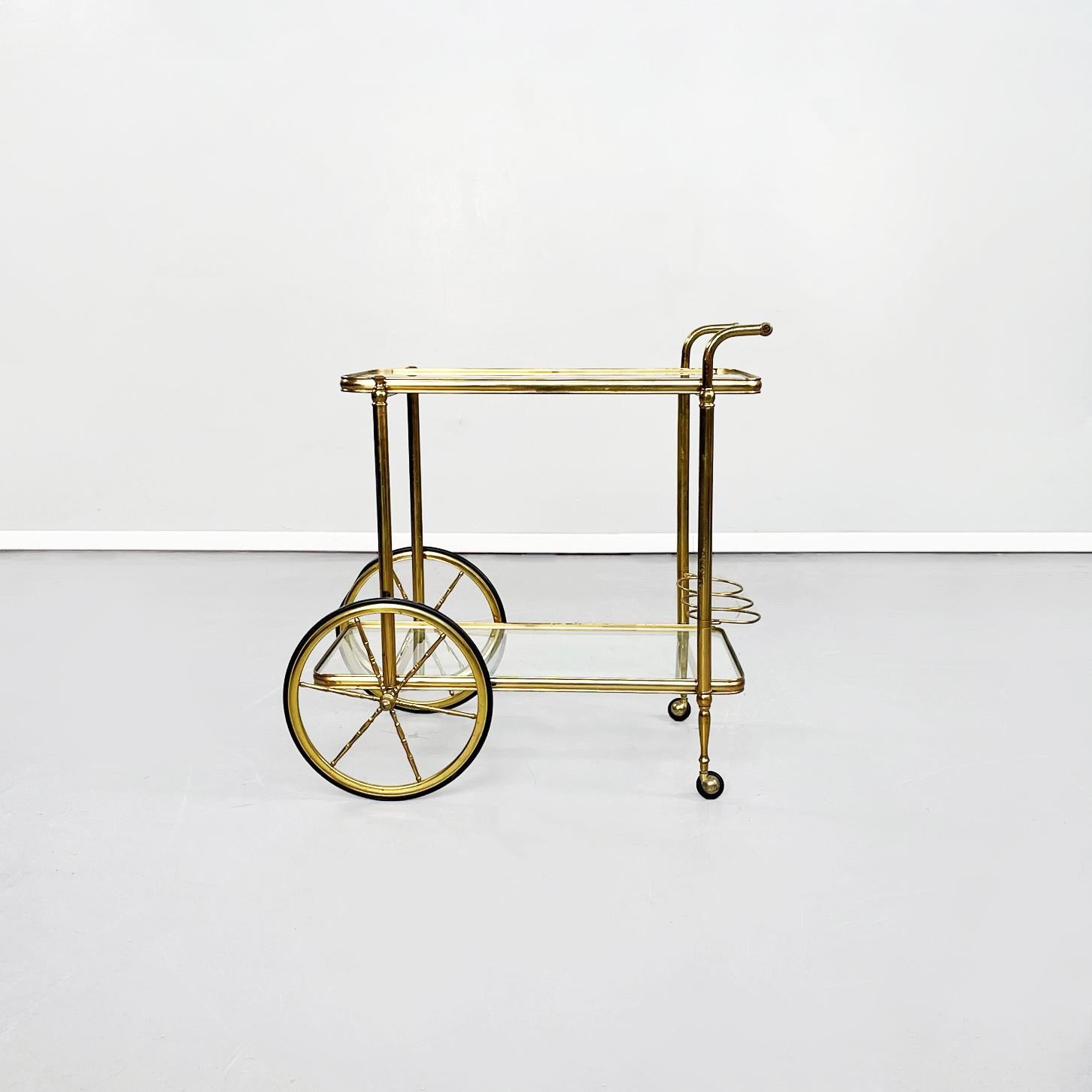 Italian Mid-Century Modern cart in brass and glass, 1950s.
Rectangular food trolley with rounded brass corners. The two floors are made up of two sheets of transparent glass, on the lower one there are three bottle holders. The bar cart has four