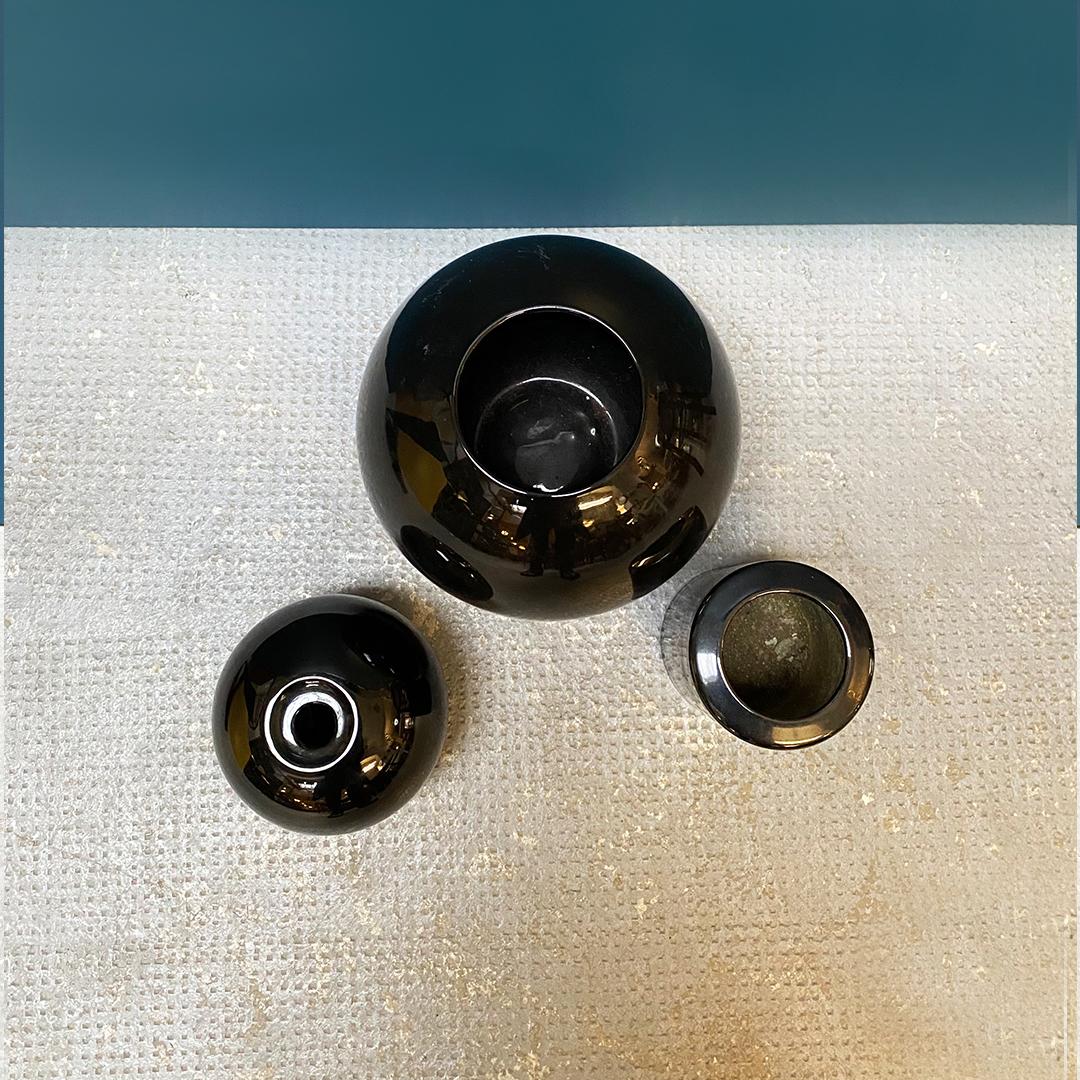 Italian Mid-Century Modern black glazed ceramic vases, 1970s.
Set of three black glazed ceramic vases, in three different sizes, 1970s.
Excellent condition, except for the cylindrical vase which has some internal defects.

Large round measures: