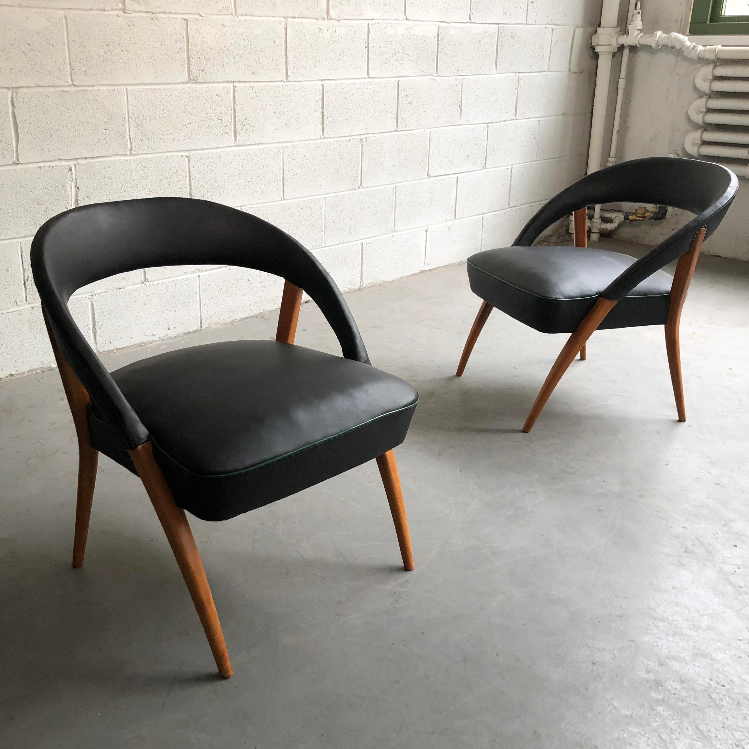 Pair of Italian, Mid-Century Modern, lounge chairs feature wonderfully shaped maple frames with rounded backs upholstered in black vinyl with green piping.