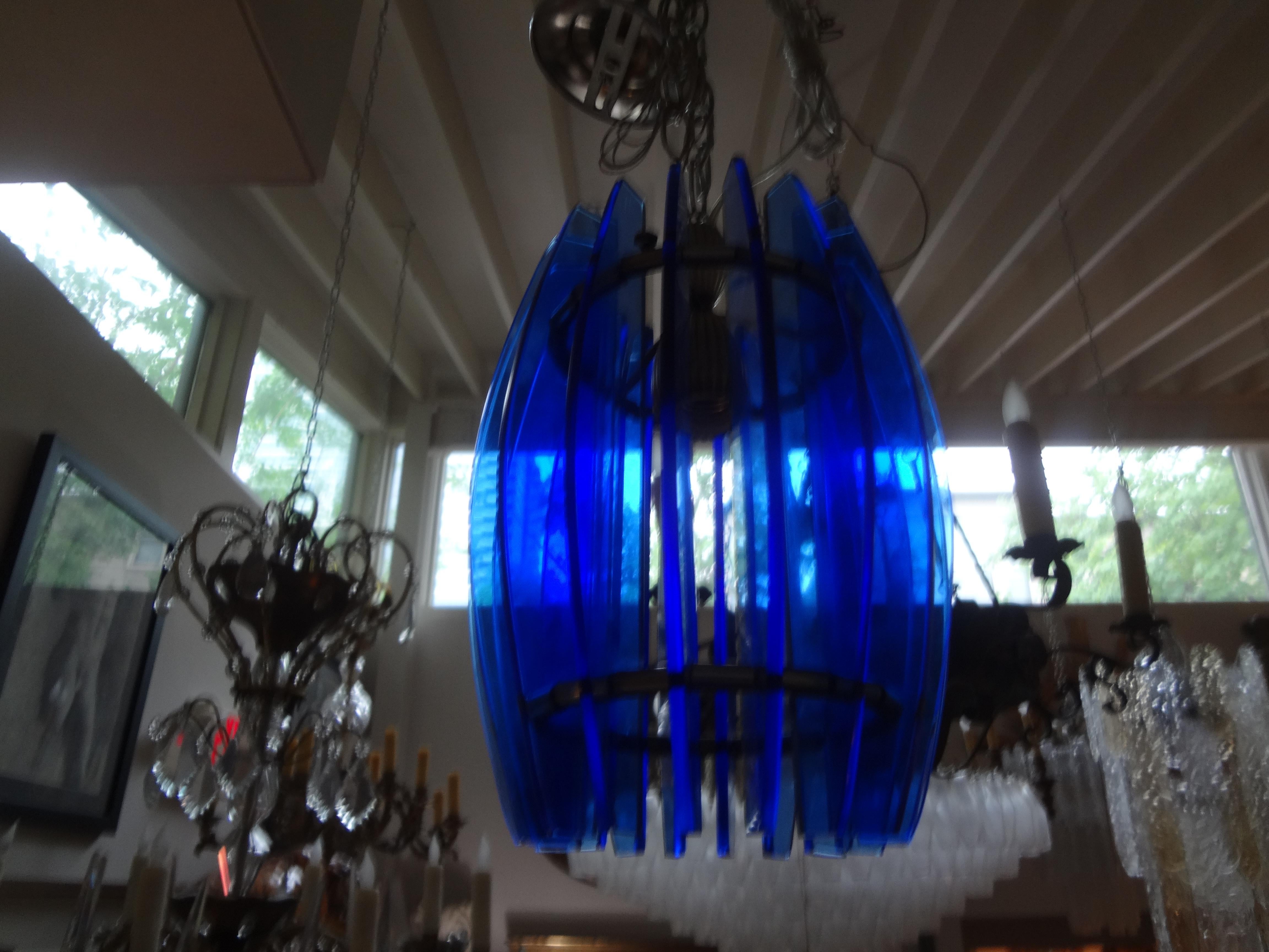 Italian Mid-Century Modern blue glass chandelier or pendant by Veca.
Charming Italian Fontana Arte inspired blue glass lantern, pendant or chandelier. This gorgeous Italian Mid-Century Modern chandelier is comprised of sheets of cobalt blue glass