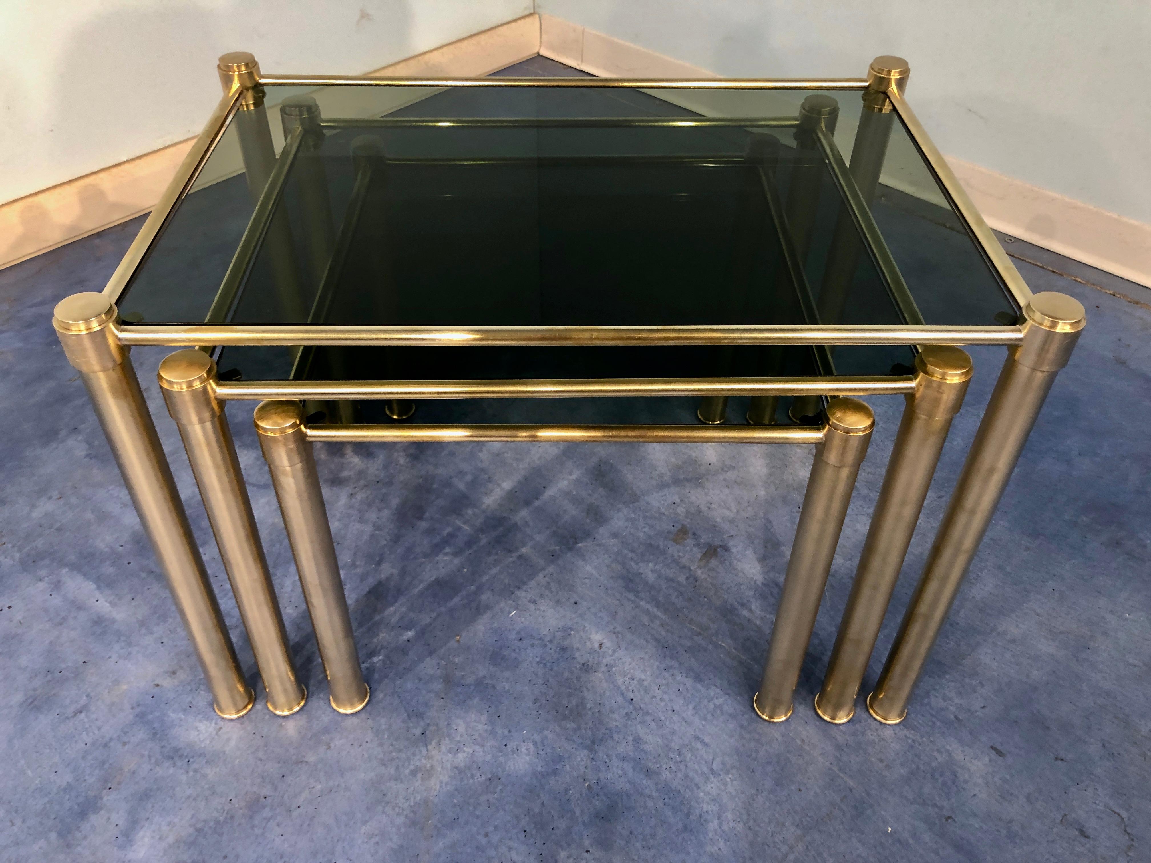 Stylish Italian Mid-Century Modern nesting tables in brass with smoked glass from the 1970s. Perfect for coffee, cocktails, and more. In very good original conditions, ready to use.