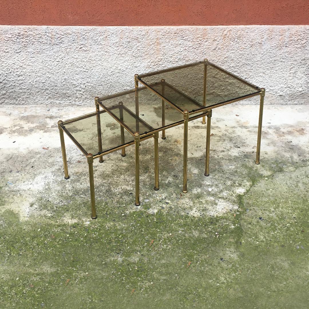 Italian Mid-Century Modern brass and smoked glass trio of coffee tables, 1970s
Brass structure trio of coffee tables with smoked glass top and can be inserted one inside the other.

Good condition, two defects on the glass, barely visible.

Large