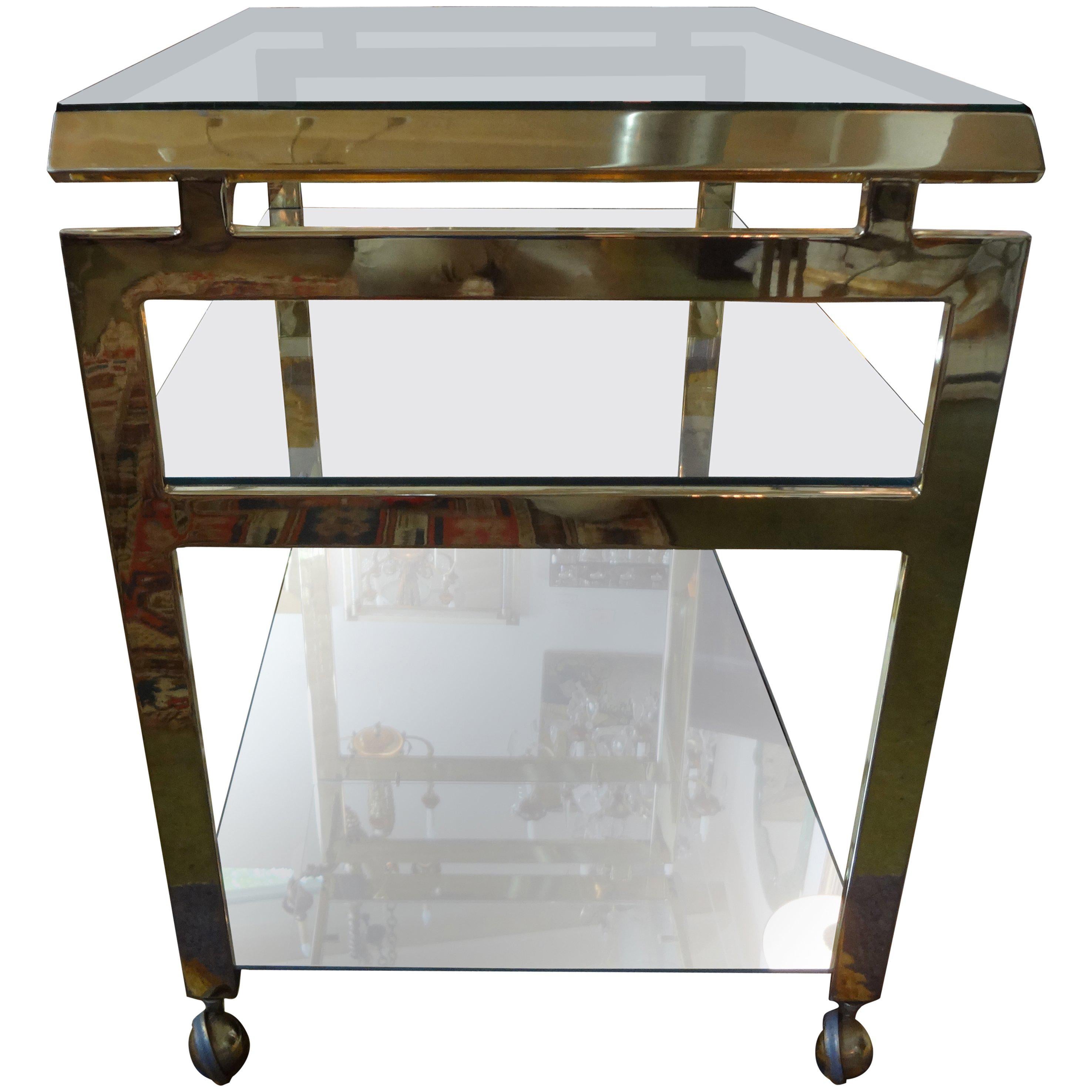 Italian Mid-Century Modern brass bar cart.
Italian Mid-Century Modern seamless brass bar cart, serving cart, drinks cart or cocktail trolley. This Italian service cart has an asian modern feel with two new glass and mirrored shelves. Featured