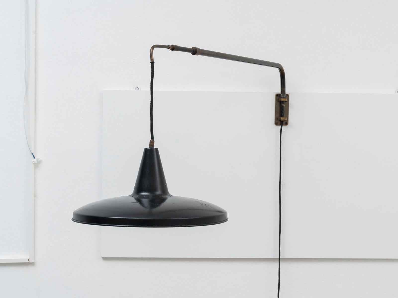 Italian Mid-Century Modern brass black Swiveling telescopic wall lamp, 1950s this counterweight wall lamp was designed in Italy in the 1950s. The designer is still unidentified, but the lamp is inspired to similar models by Arredoluce and Arteluce.