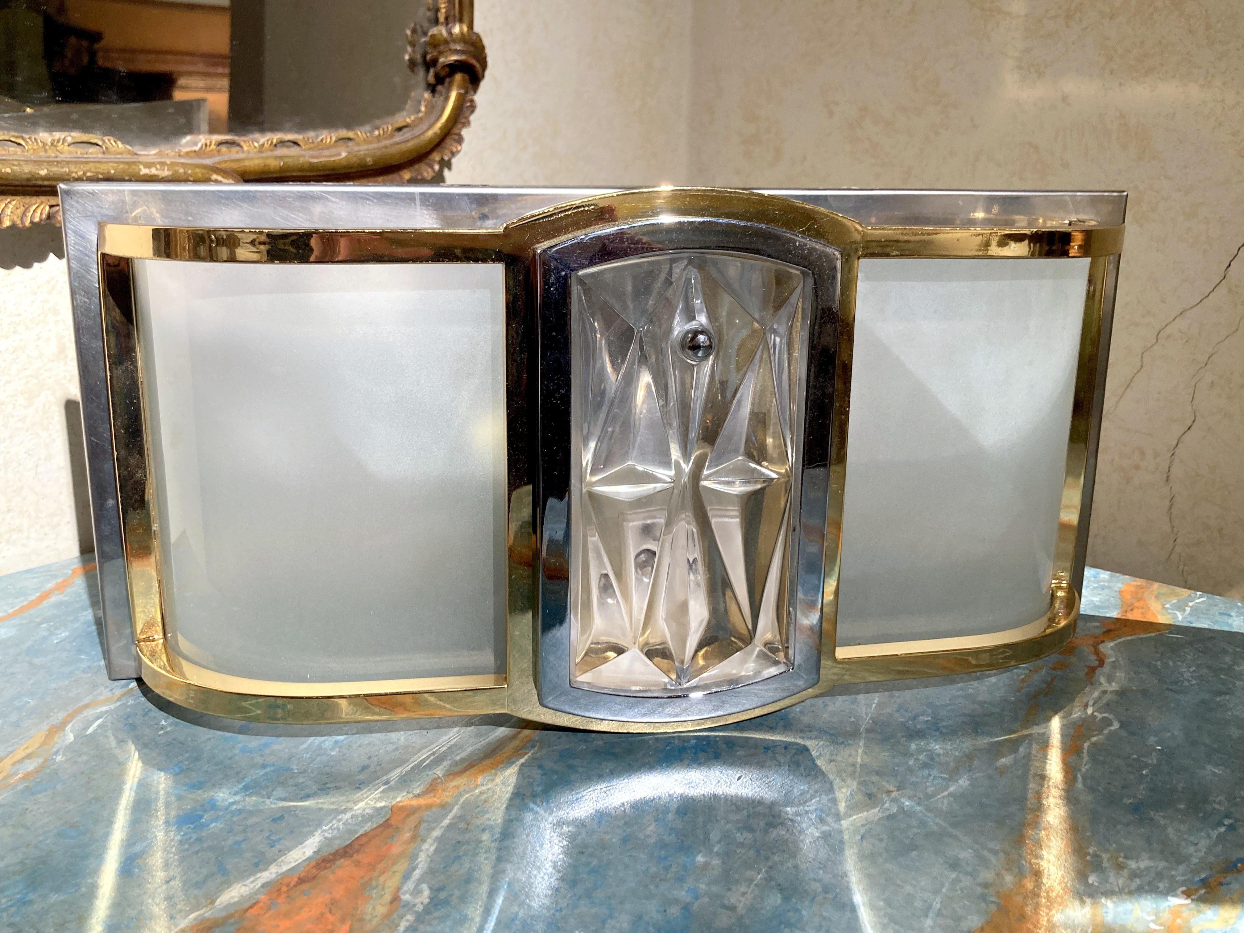 This stylish Italian Mid Century Modern pair of wall sconces or ceiling lights is an attractive light fixture set made of curved shaped frosted glass panels inserted in a polished brass frame mounted on a chrome panel, each sconce houses two light