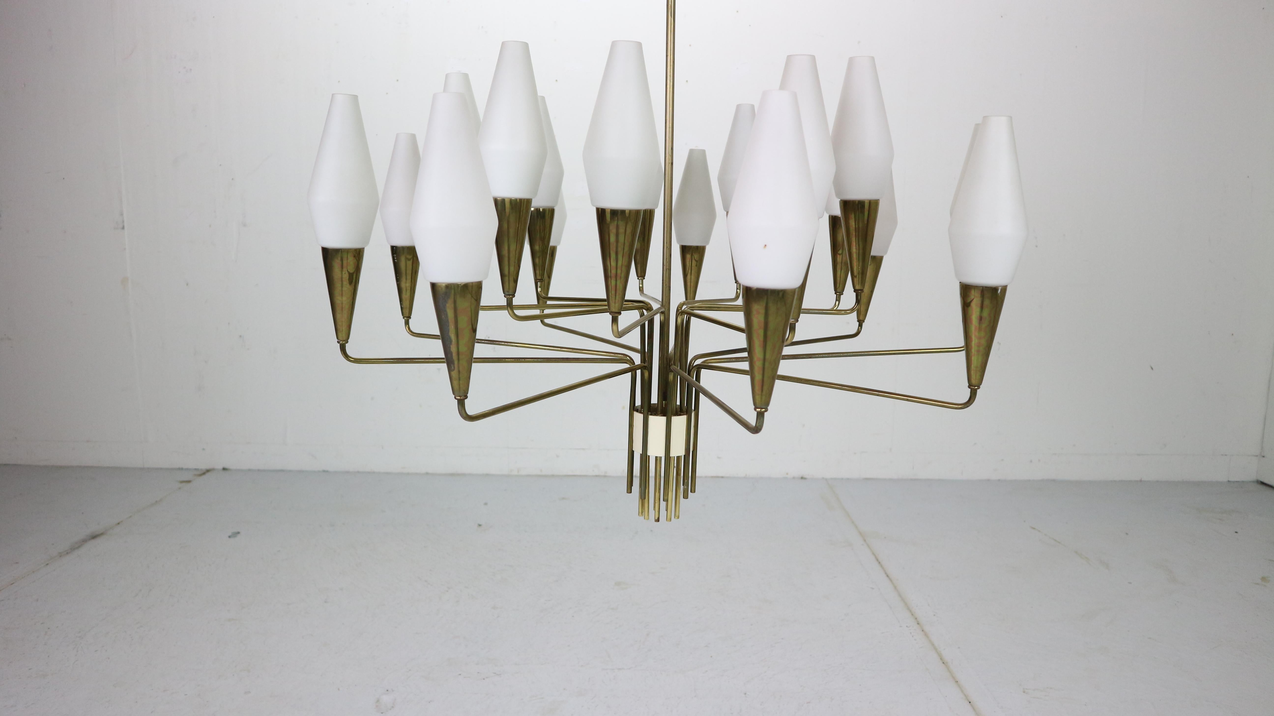 Mid-Century Modern period very elegant 18-armed large chandelier made in Italy, 1960s period.
The entire frame is made of brass. 18 opaline glass shades gives a lot of light.
Very good condition and fully functional lamp in original