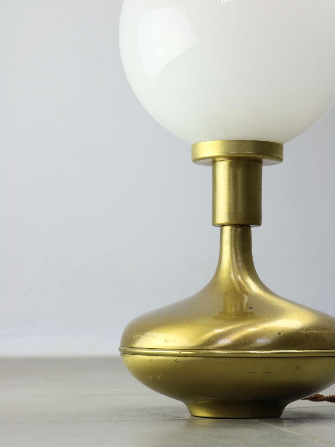 Beautifully formed table lamp in brass and opaline glass. 

The lamp socket is designed for standard European E14 light-bulb (not included).

For US customers, an adapter for the lightbulb (E14 to E12) will be added to the package. Additionally