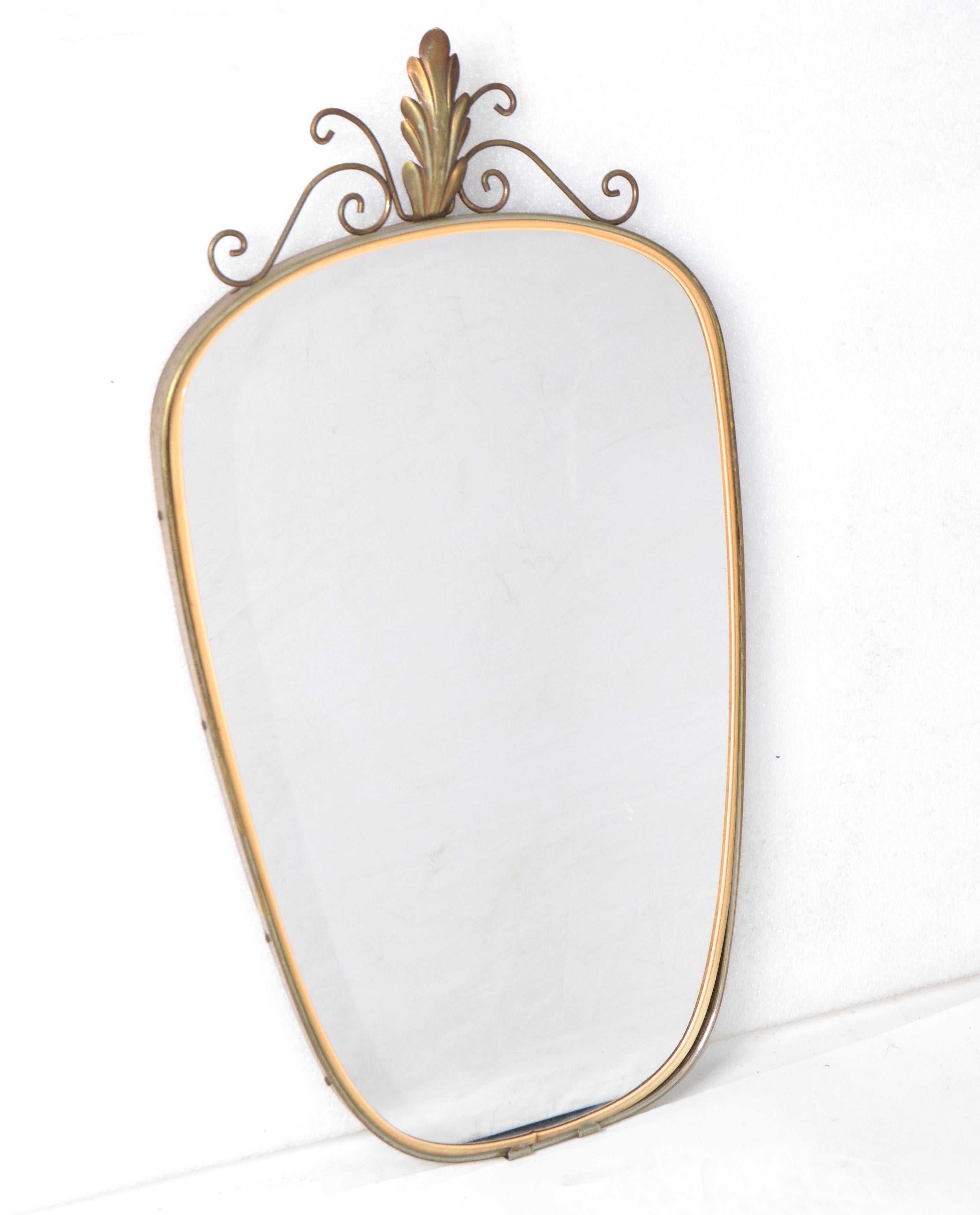 Specchio da parete a scudo in ottone di stile Mid-Century Modern realizzato in Italia negli anni '60.
 