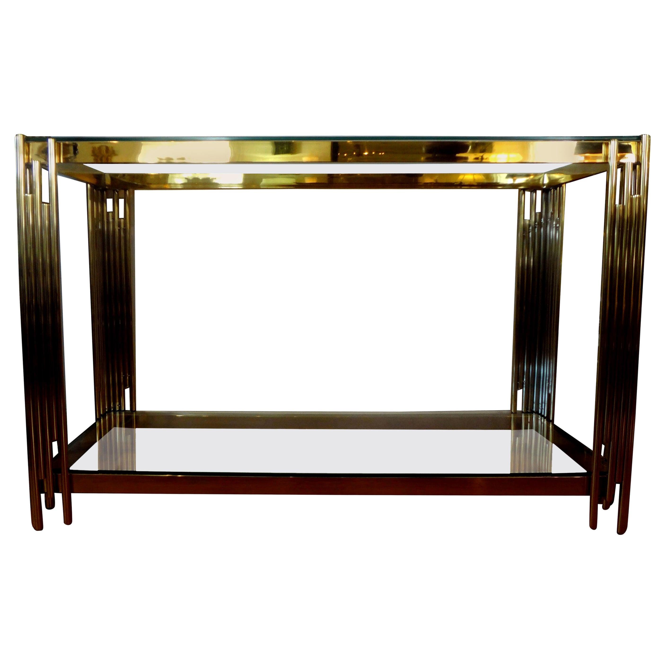 Stunning Italian modern brass two-tiered console table with glass tops. This fabulous Italian midcentury Romeo Rega style free standing Italian made geometric modernist console table is in very good vintage condition and can be used as a sofa table
