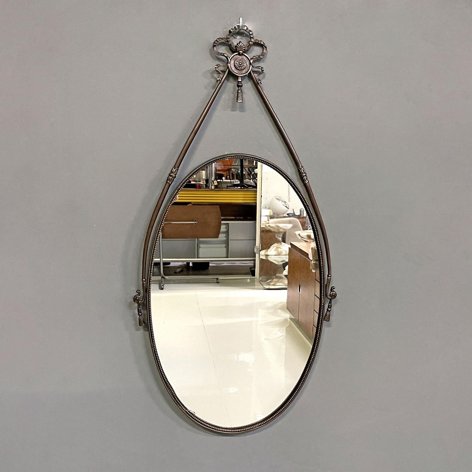 Italian mid-century modern brass wall mirror with ribbon and decorations, 1950s
Oval brass wall mirror. The load-bearing structure is composed of two decorated round-section arms joined at the top by a finely crafted bow-shaped decoration. The