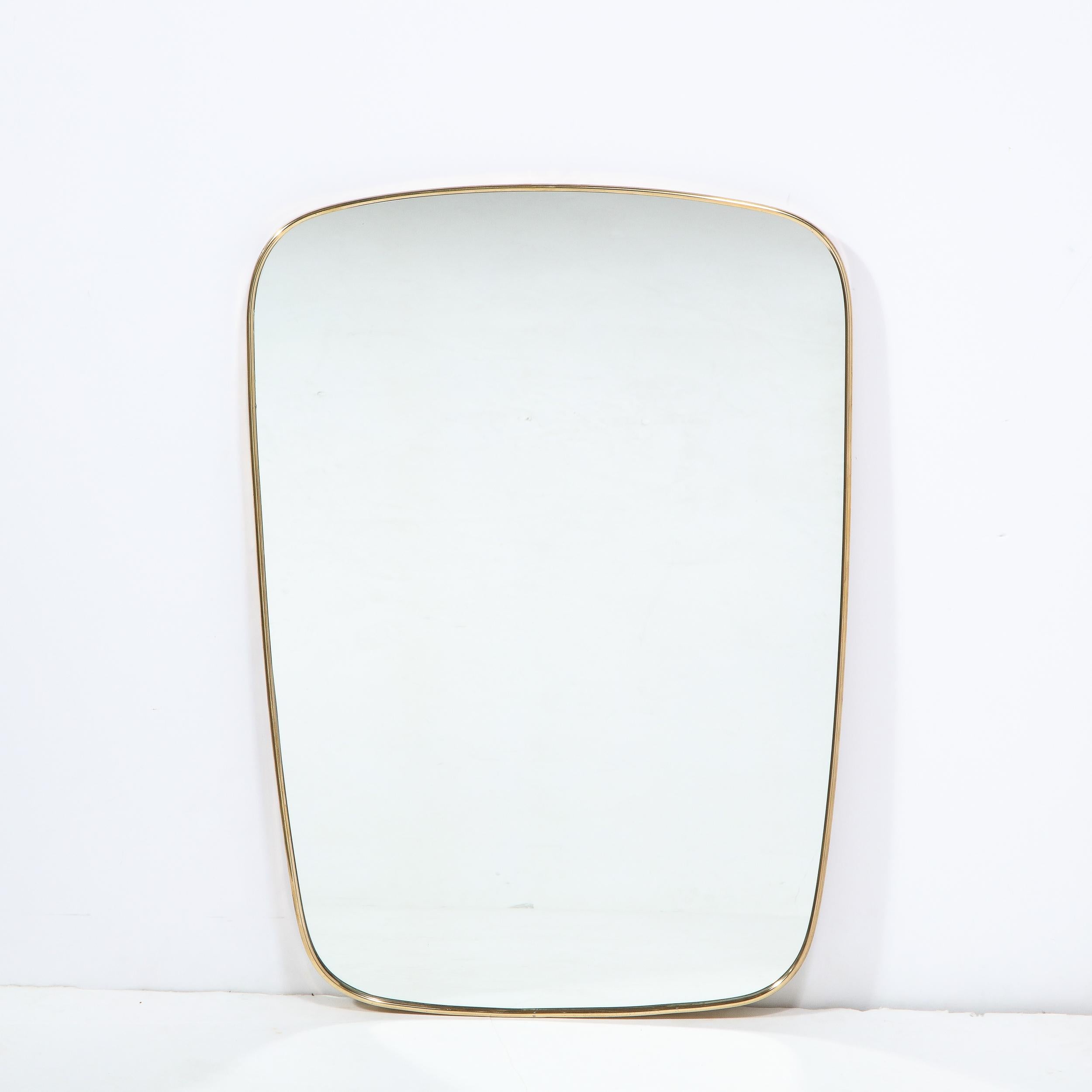 This elegant and understated Mid-Century Modern wall mirror was realized in Italy, circa 1950. It features a rectangular form with rounded corners tapering slightly toward the bottom. This piece is a study in the simplicity of great design, quietly